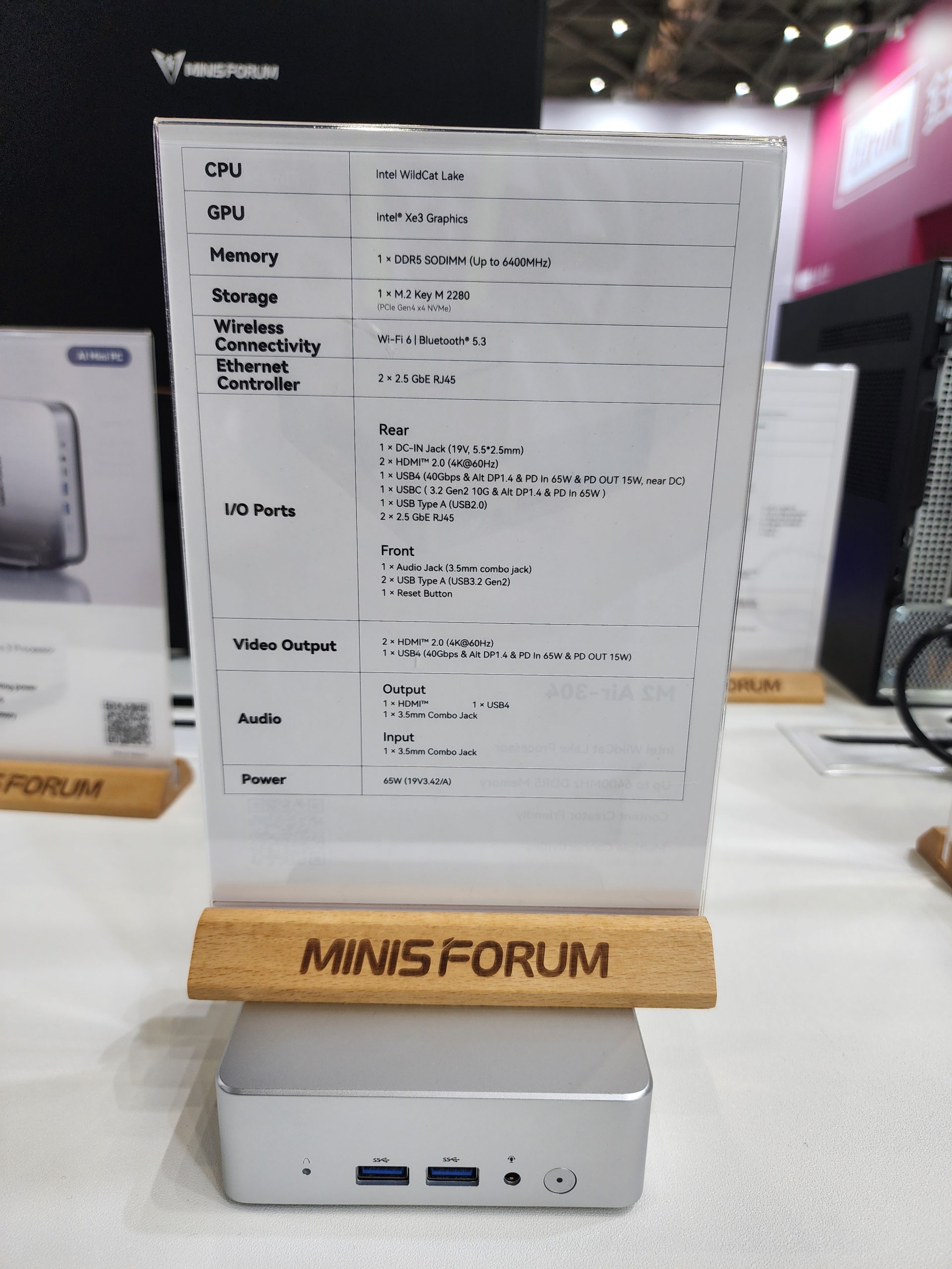 A Minisforum mini PC display shows specifications including 'Intel Xe3 Graphics' and 'Intel WildCat Lake' CPU, along with features like 2.5 GbE RJ45, Wi-Fi 6, and Bluetooth 5.3.