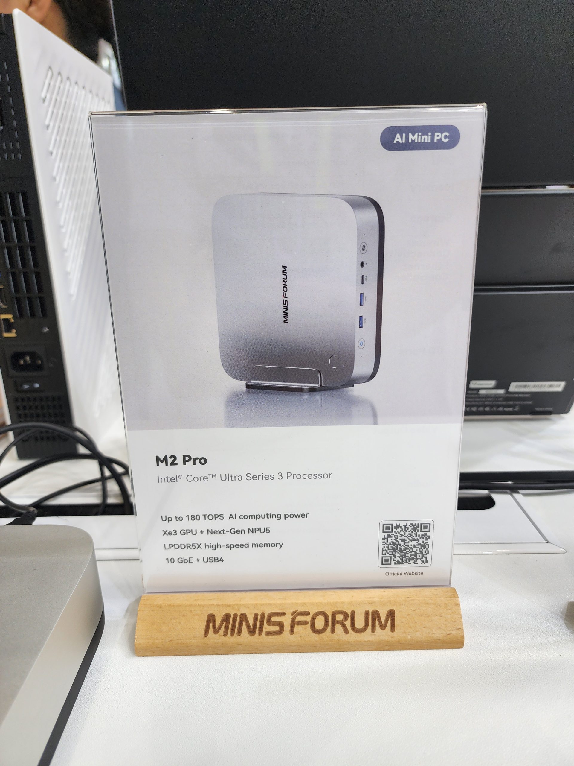 The image shows a MINISFORUM M2 Pro with an Intel Core Ultra Series 3 Processor, featuring 'AI Mini PC,' capable of up to 180 TOPS AI computing power, Xe3 GPU + Next-Gen NPU5, LPDDR5X high-speed memory, 10 GbE, and USB4.