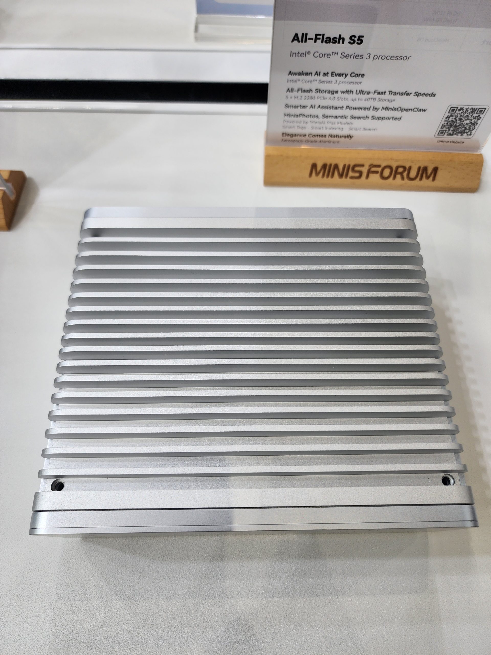 A Minisforum All-Flash S5 with an Intel Core Series 3 processor is displayed on a countertop.