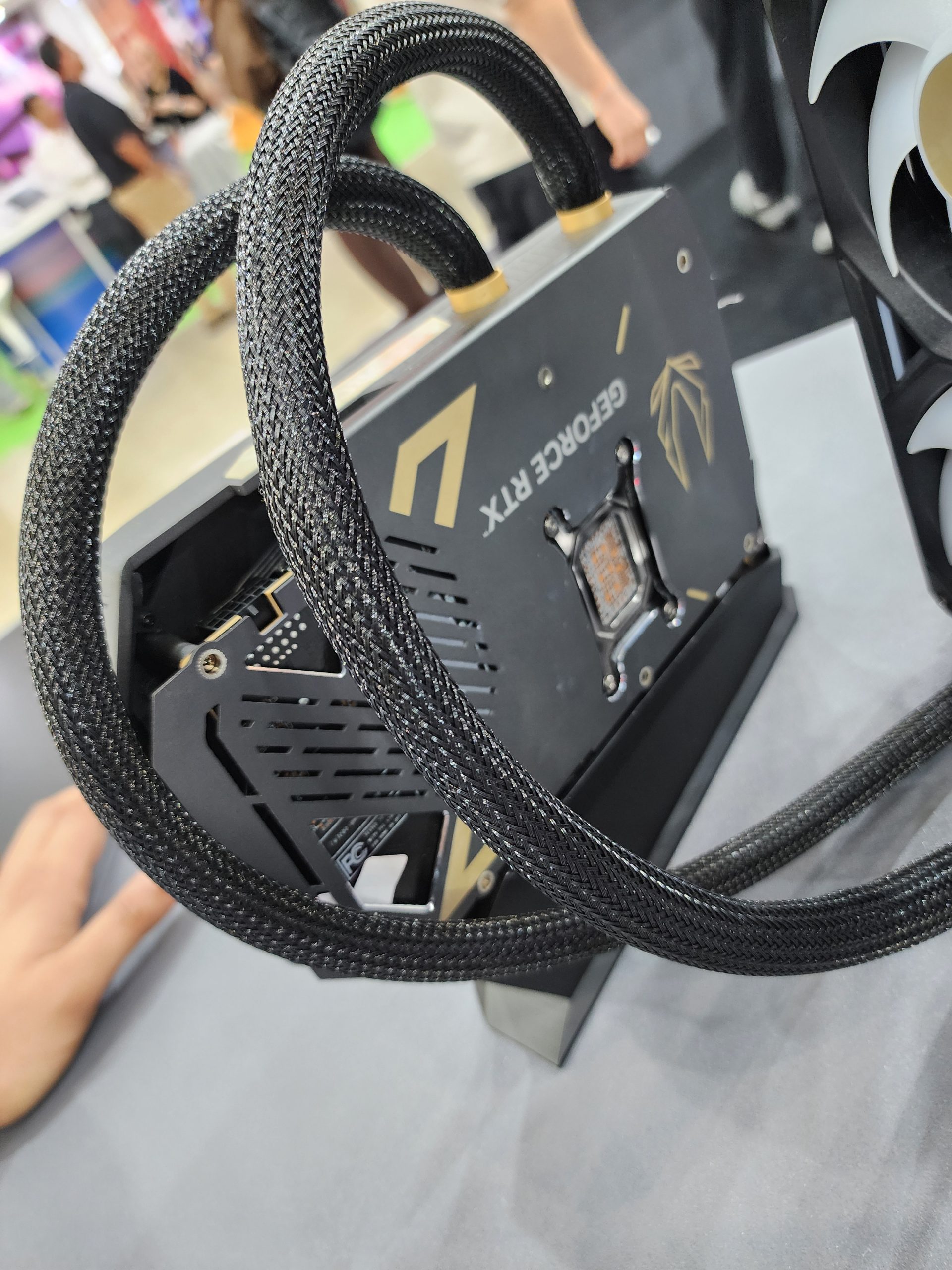 A GeForce RTX graphics card with custom water cooling tubes on display.