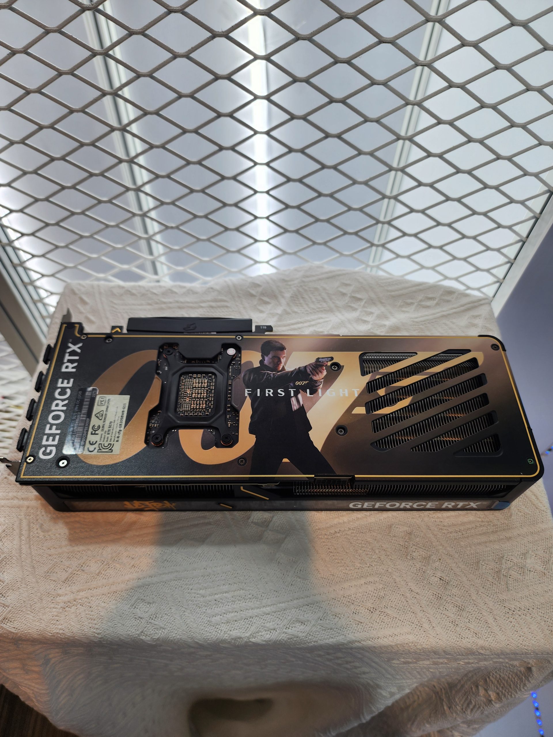 NVIDIA GeForce RTX graphics card featuring a custom backplate design with an image of a character, labeled 'FIRST LIGHT', and visible cooling vents.