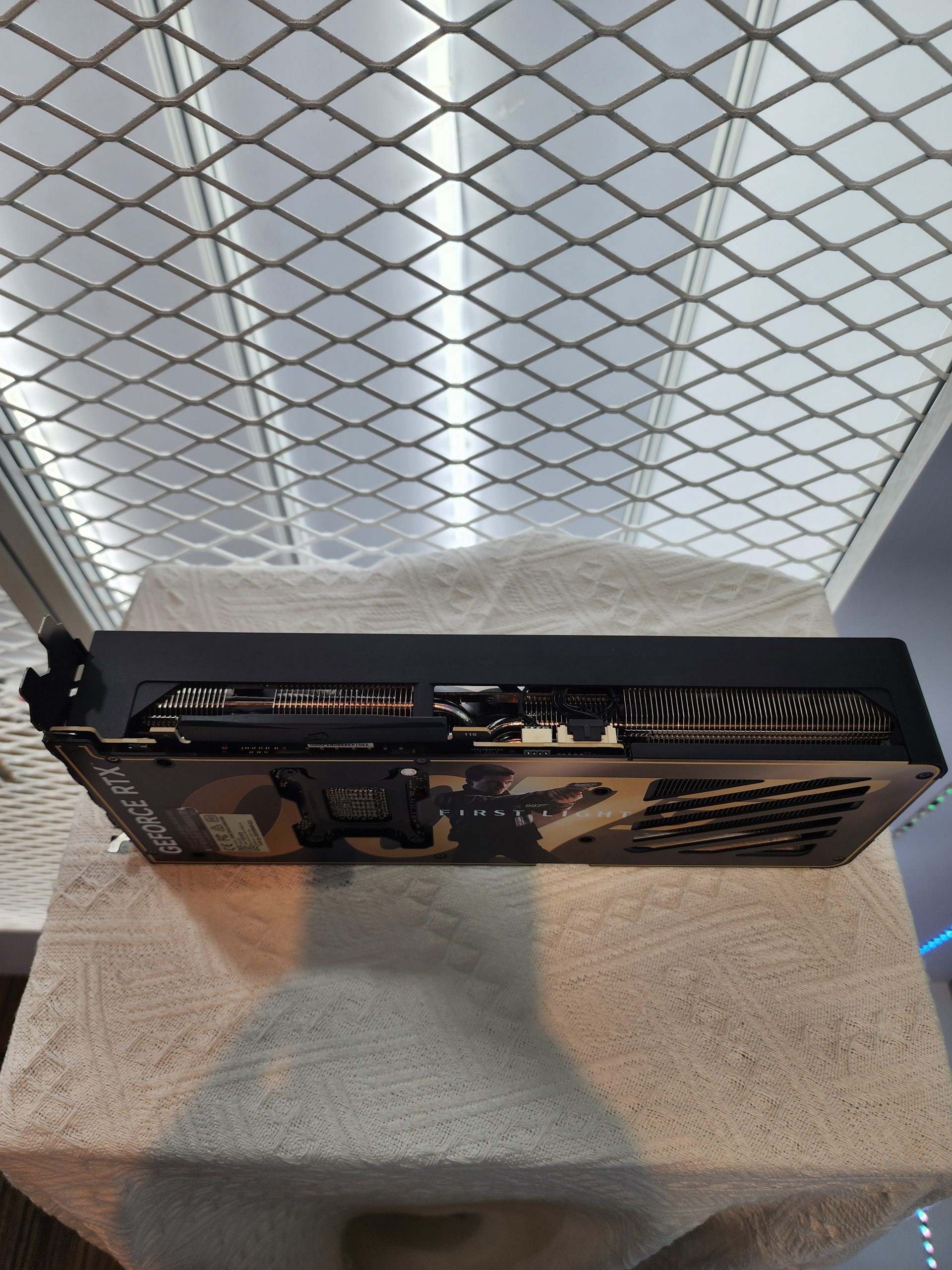 A custom-designed NVIDIA GeForce RTX graphics card with a themed backplate featuring characters from the game Forspoken is displayed on a textured surface.