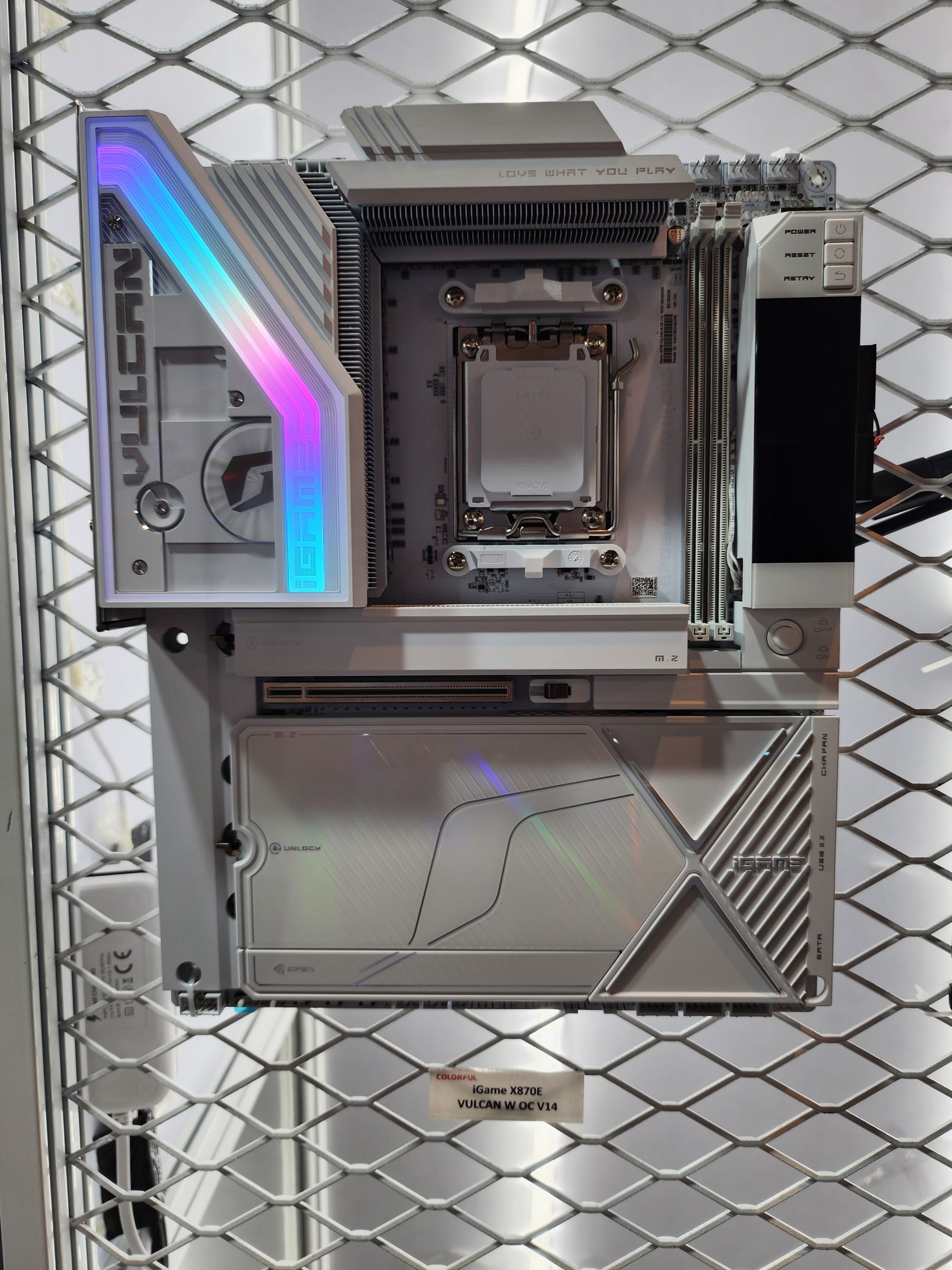 The Colorful iGame X870E Vulcan W OC V14 motherboard is displayed with RGB lighting and visible text saying 'LOVE WHAT YOU PLAY.'