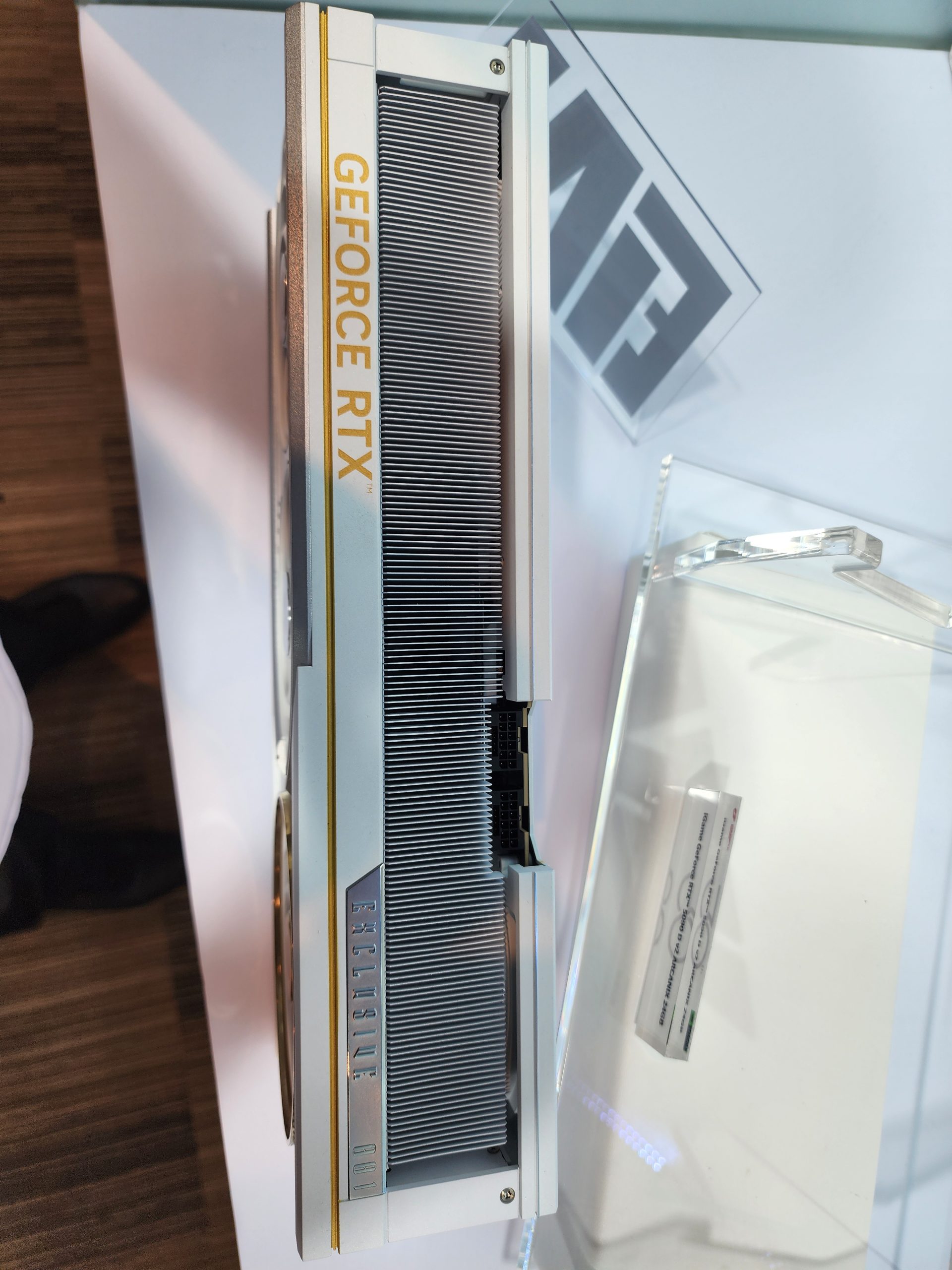 A silver NVIDIA GeForce RTX graphics card is displayed vertically, showing GeForce RTX in yellow and Exclusive 001 engraved on the side.
