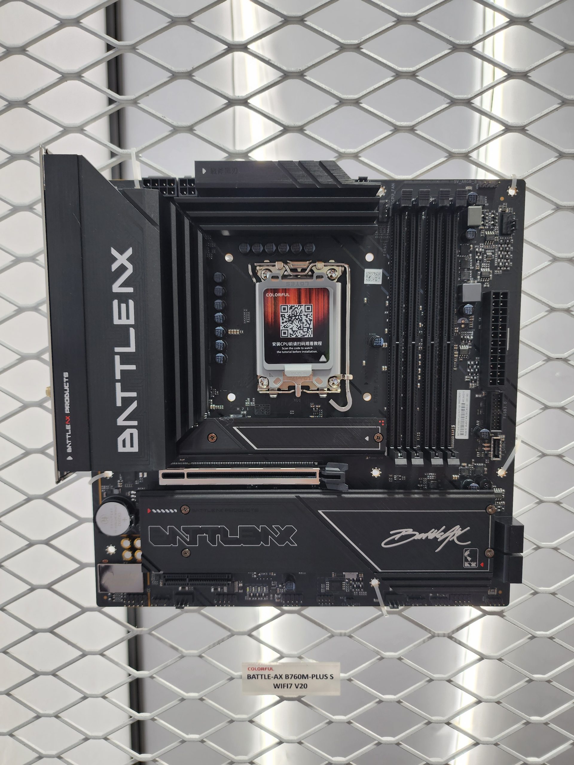 A COLORFUL BATTLE-AX B760M-PLUS S motherboard displayed, featuring the BATTLE-AX branding and a QR code on the CPU socket, with a label reading 'BATTLE-AX B760M-PLUS S WIFI7 V20' below.
