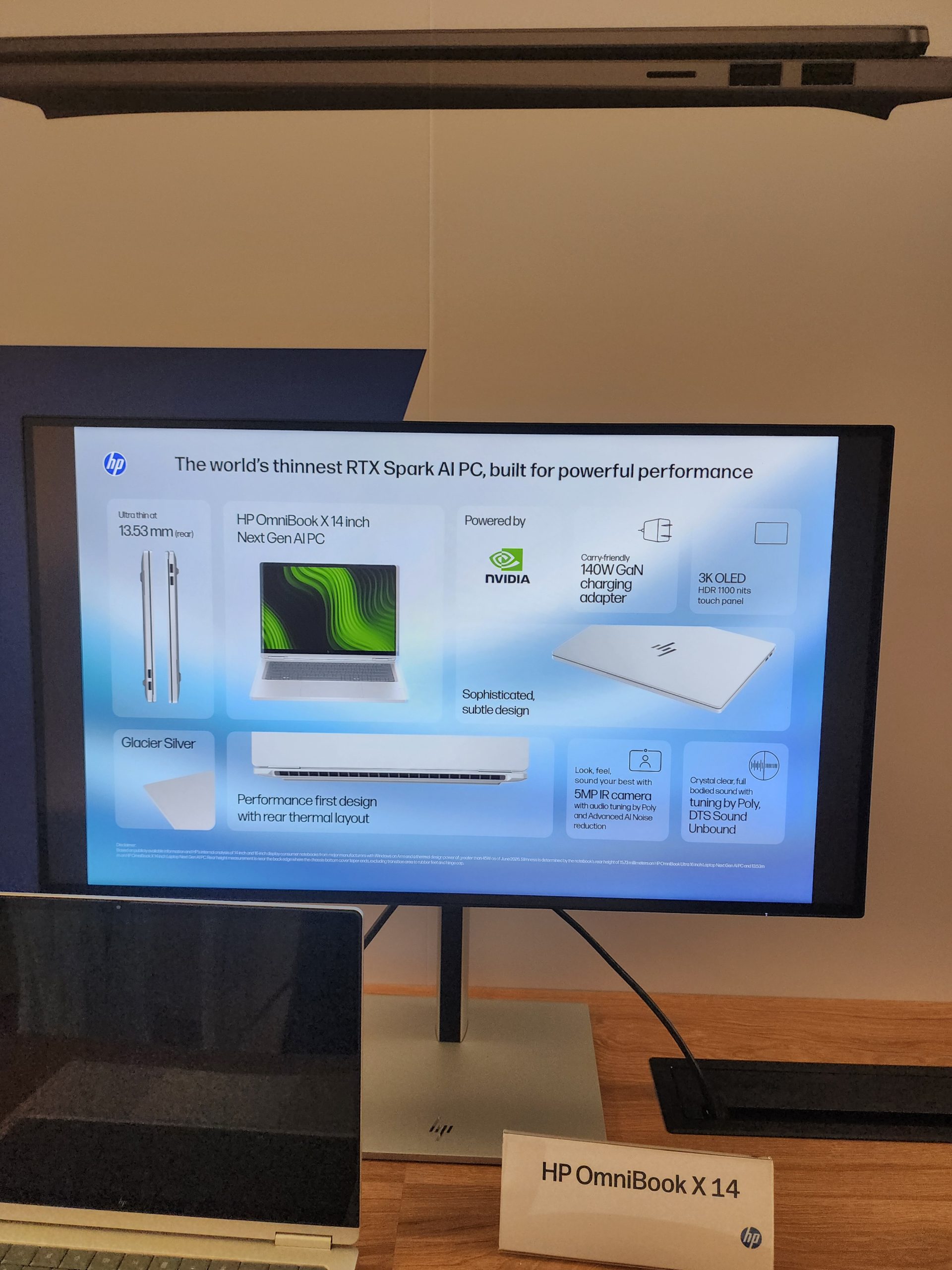 A presentation slide showcasing the HP OmniBook X 14 inch Next Gen AI PC featuring an NVIDIA RTX Spark AI, '3K OLED HDR' display, and a '140W GaN charging adapter.'