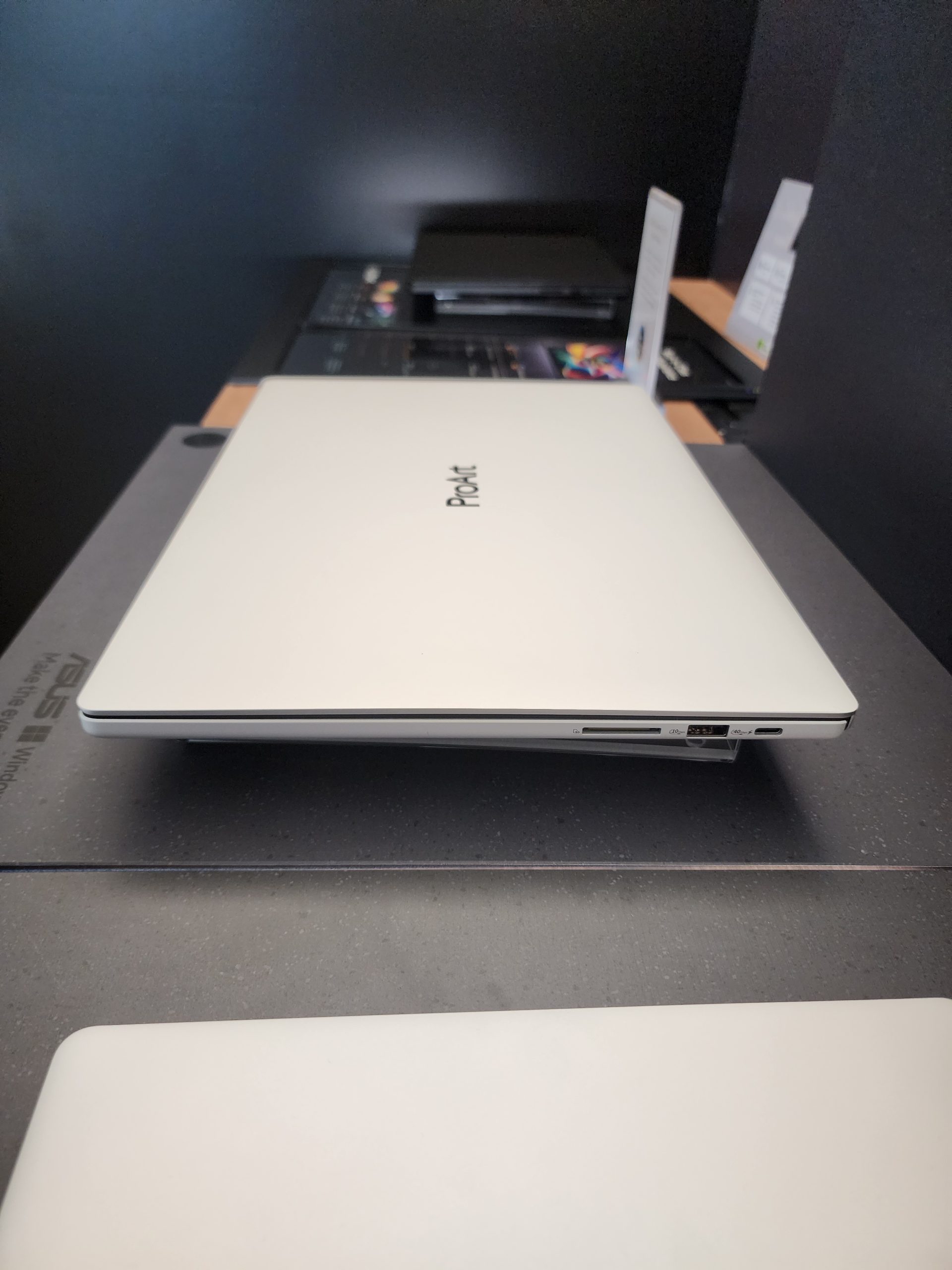 An ASUS ProArt laptop is displayed on a surface, showcasing its sleek design and closed lid.