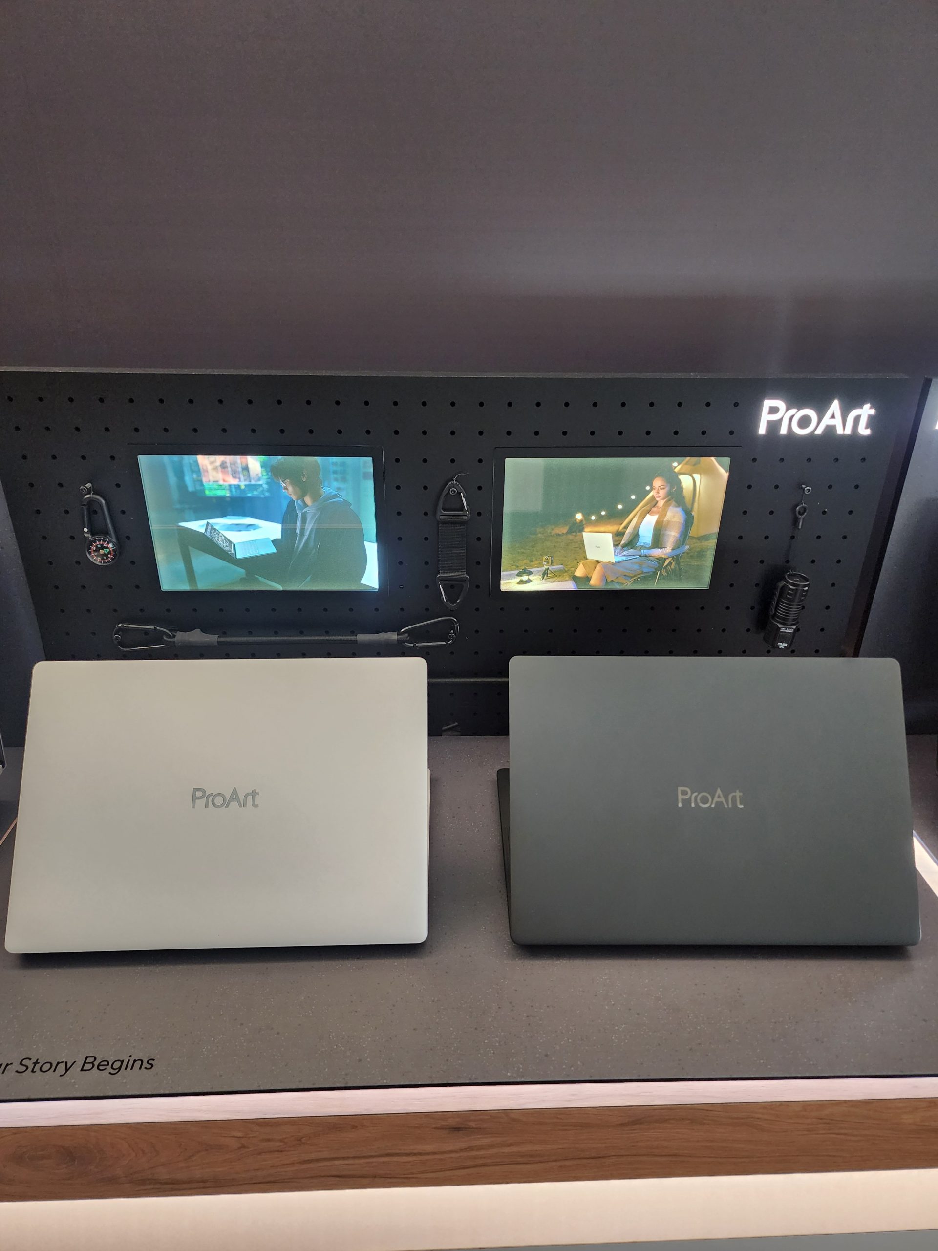 Two ASUS ProArt laptops displayed in front of a 'ProArt' branded board with screens showing two different people using similar laptops.