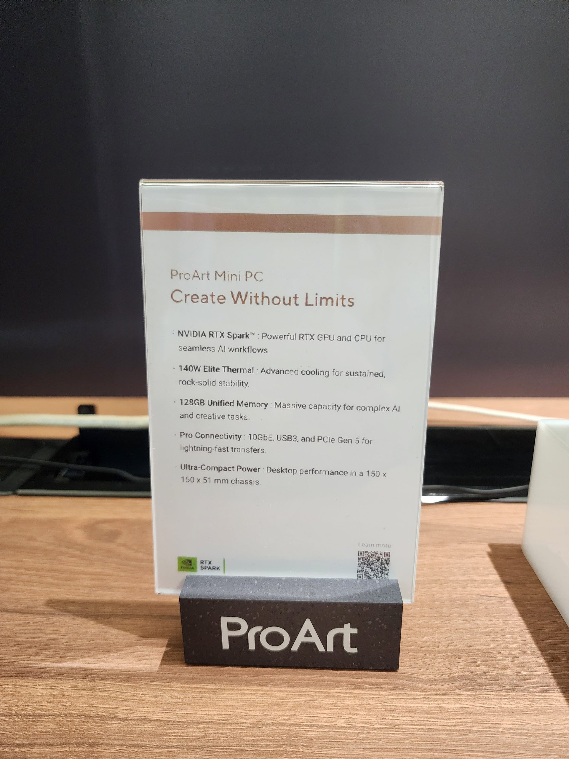 A sign details the features of a ProArt Mini PC with 'Create Without Limits,' highlighting the NVIDIA RTX Spark GPU, 140W Elite Thermal cooling, 128GB unified memory, Pro Connectivity with 10GbE and PCIe Gen 5, and ultra-compact power in a 150 x 150 x 51 mm chassis.