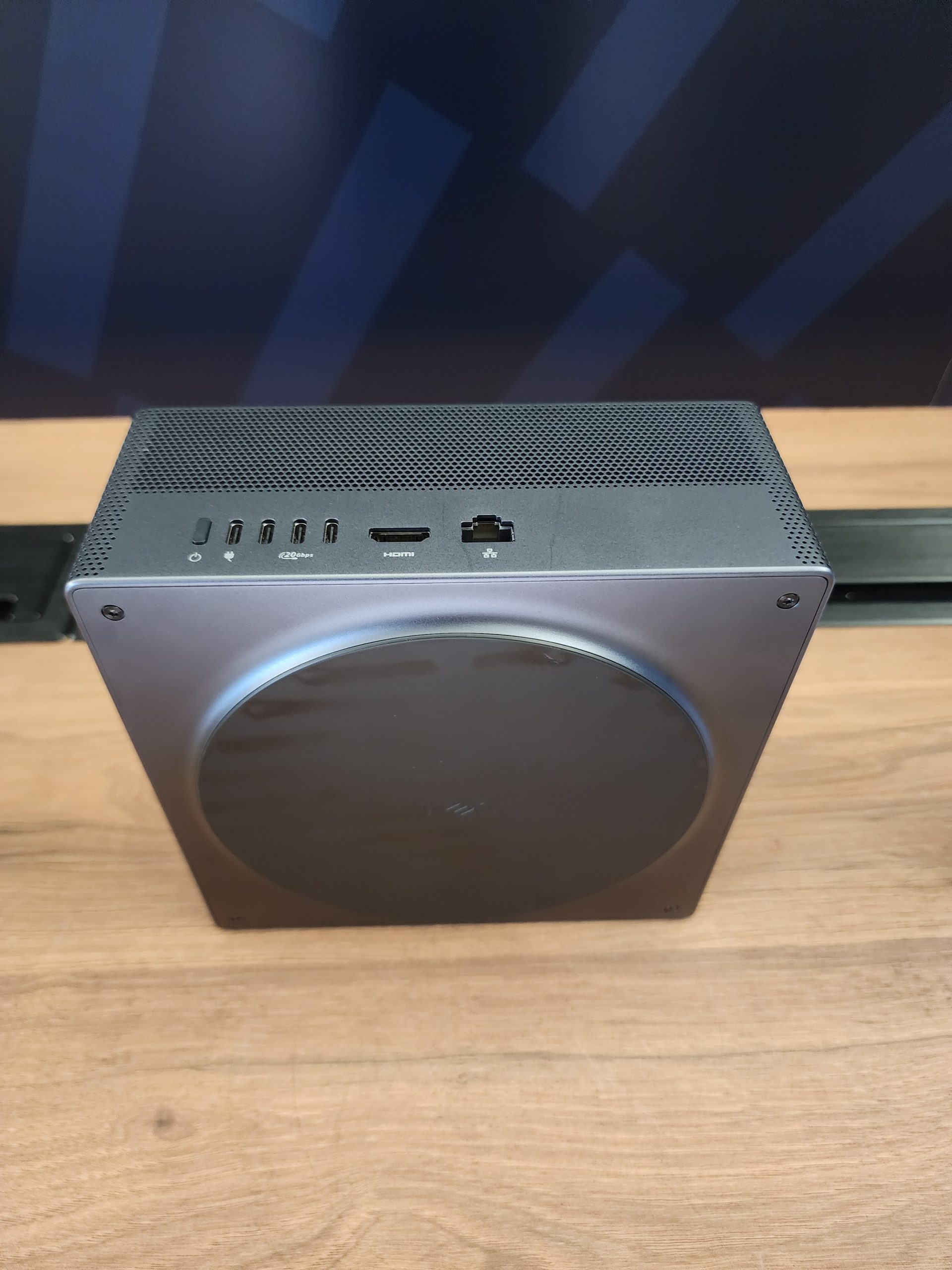 A top-down view of an Xbox Series S displaying its ports, including USB, HDMI, and Ethernet connections, on a wooden surface.