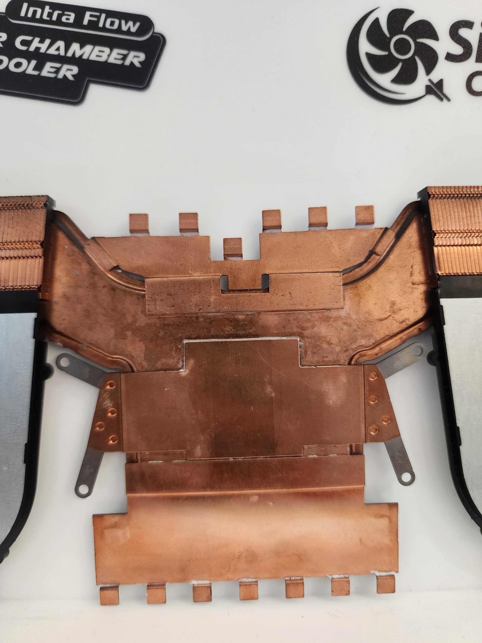 A copper heatsink labeled 'Intra Flow,' part of a 'Vapor Chamber Cooler,' displayed alongside a fan logo and company branding.