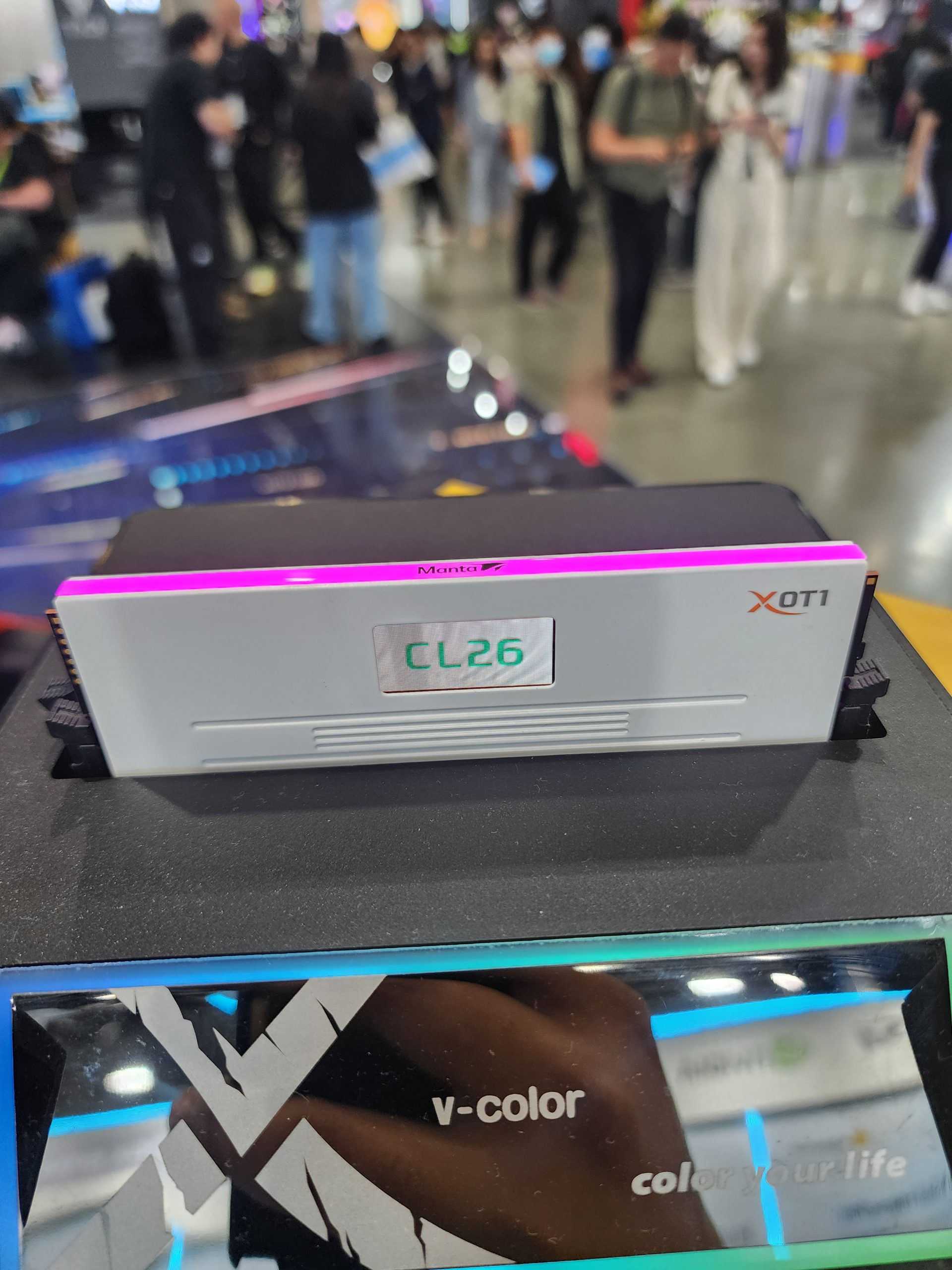 A v-color XOT1 Manta RAM module is displayed with the text 'CL26' visible in a tech showroom.