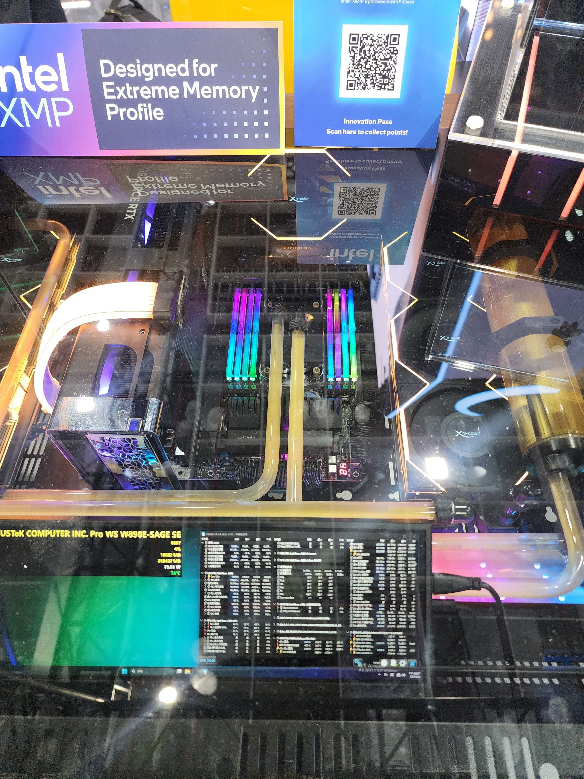 An ASUS Pro WS W790E-SAGE SE motherboard setup is displayed with RGB RAM sticks and water cooling tubes, featuring the text 'Designed for Extreme Memory Profile' next to Intel branding.