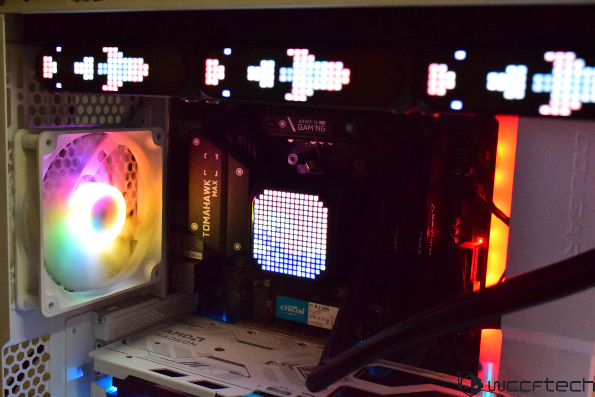 A gaming PC featuring an MSI TOMAHAWK MAX motherboard, an AMD Radeon graphics card, a 'CRUCIAL P1 M.2 2280' storage drive, and vibrant RGB lighting.