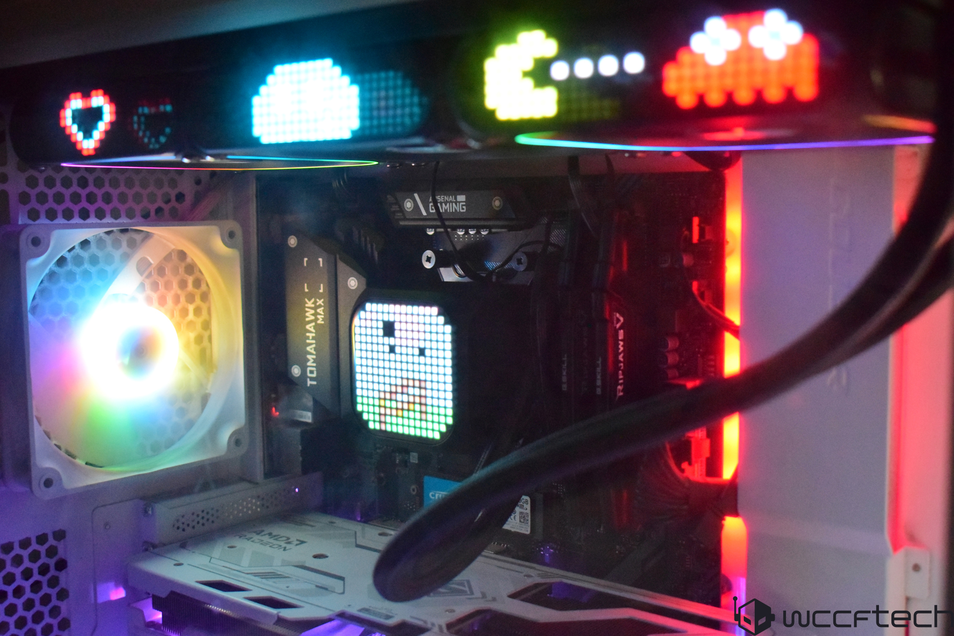 A desktop PC setup features a MSI MAG B550 TOMAHAWK MAX WiFi motherboard with RGB lighting and a pixel art display of Pac-Man characters inside the case.