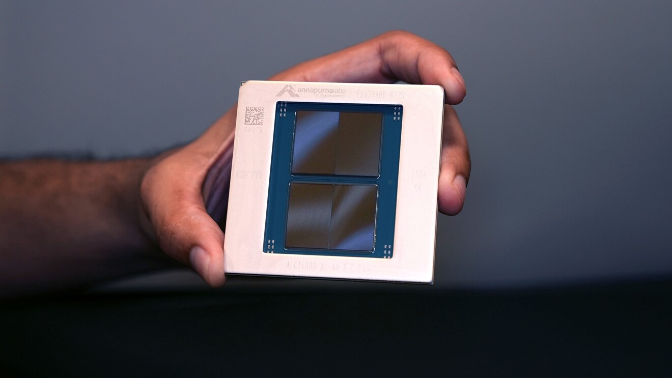 A person holds an Annapurna Labs chip with visible branding and dual die layout.