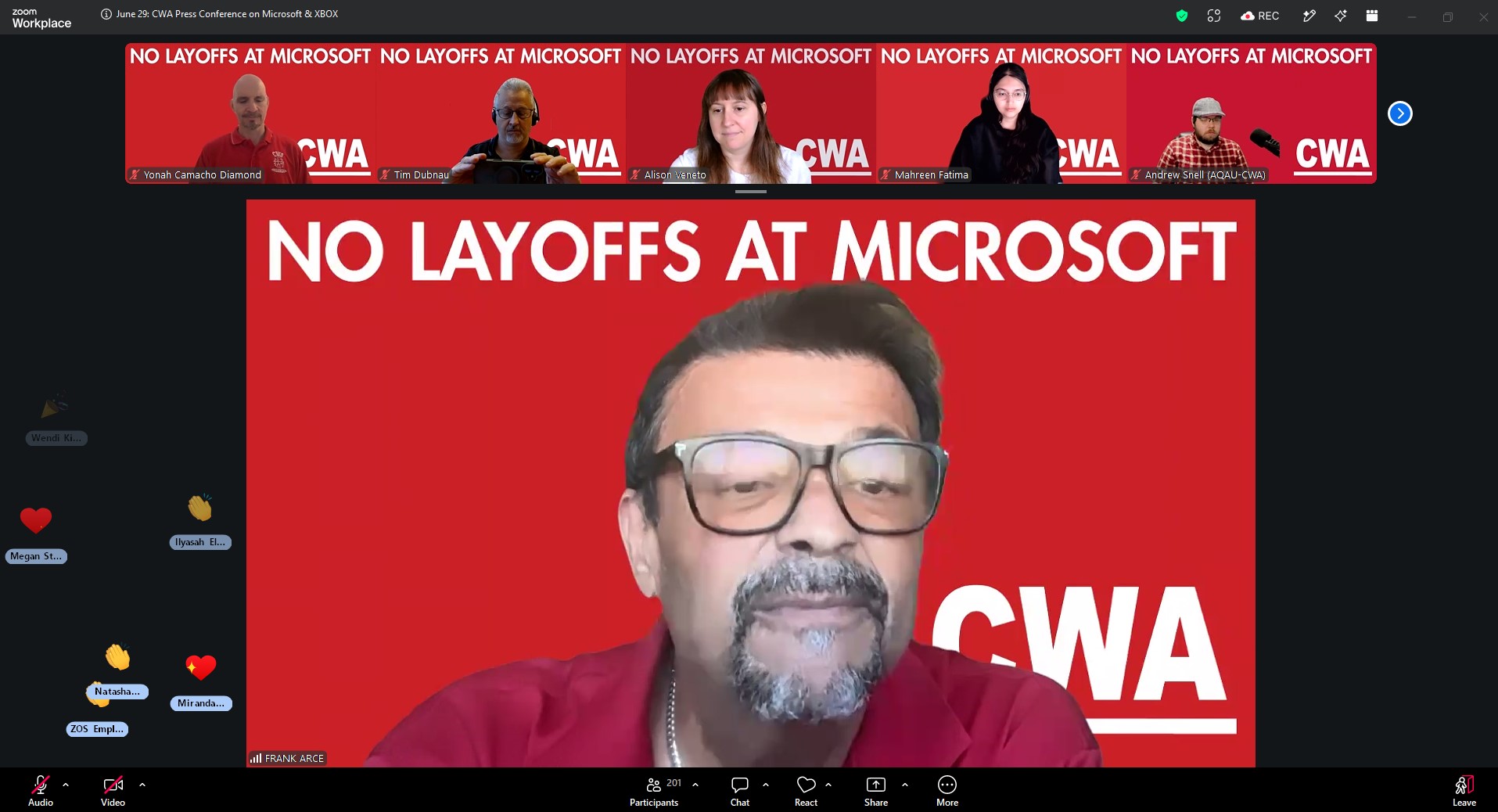 A Zoom conference call shows participants with a red background displaying 'NO LAYOFFS AT MICROSOFT' and 'CWA'.