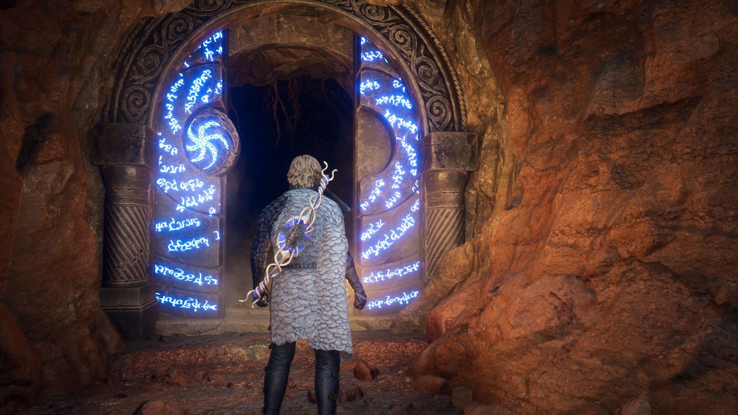 A character in Elden Ring standing before a glowing, rune-covered stone doorway in a rocky cave.