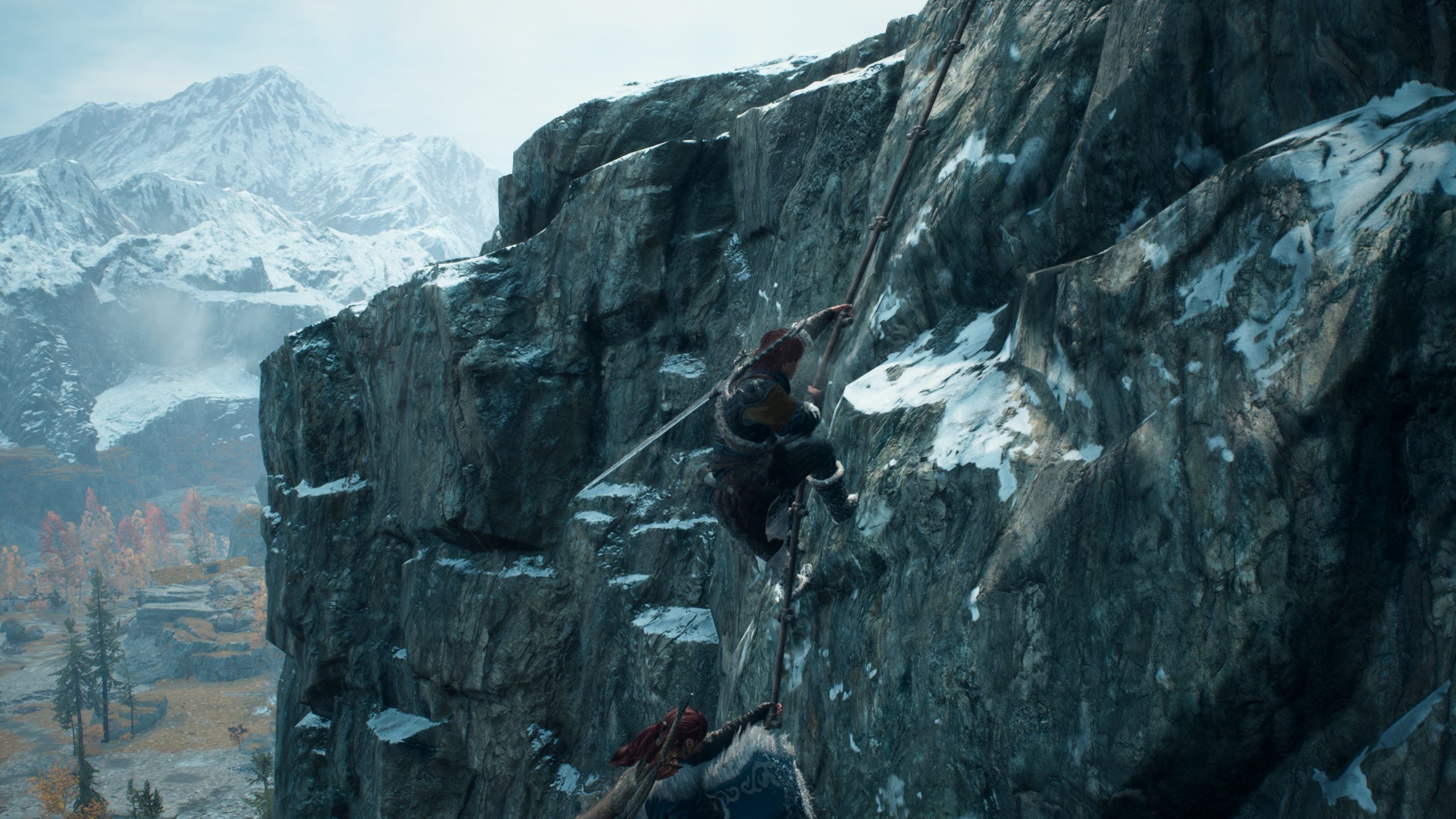 A character in 'Assassin’s Creed Valhalla' is climbing a snowy mountain cliff using a rope against a scenic backdrop of snowy peaks.