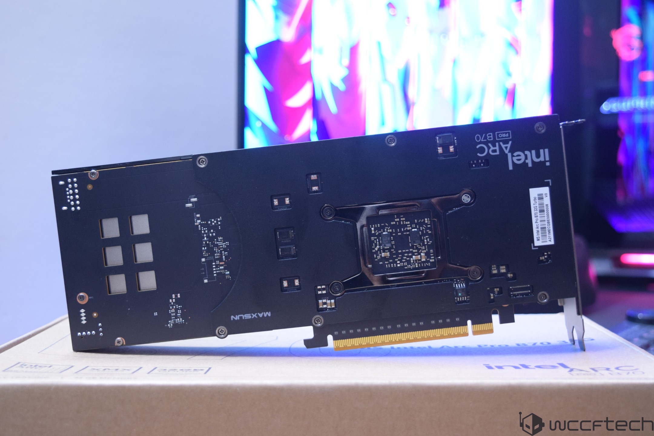 The Intel Arc Pro B70 graphics card is displayed on a box with colorful computer screens in the background.