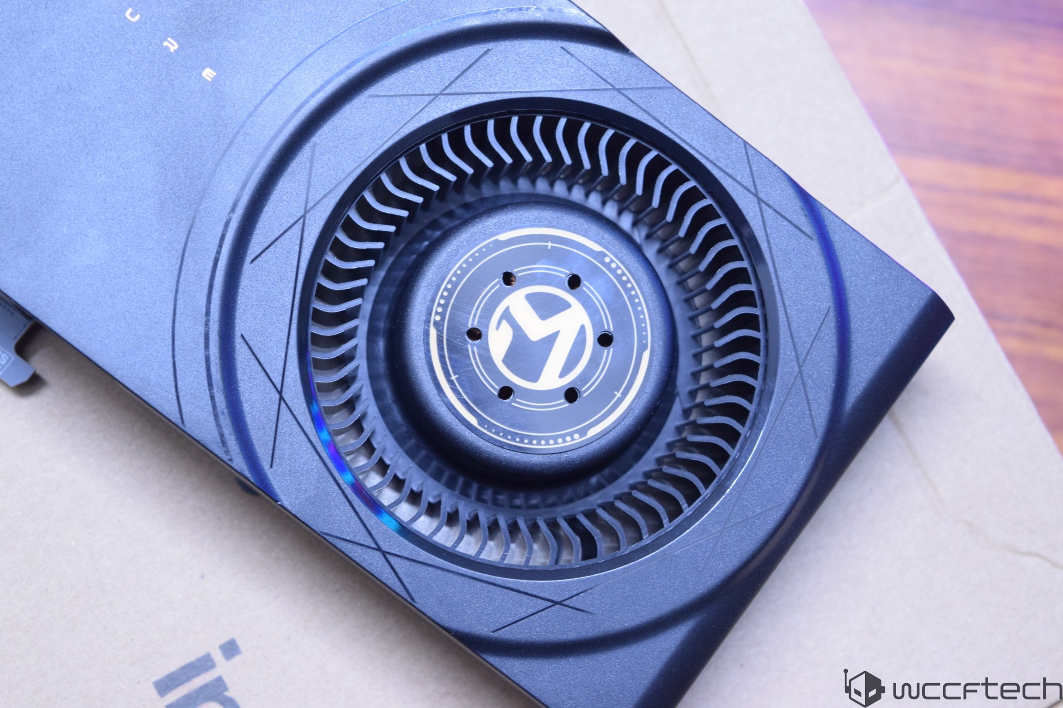 A close-up of an Intel Arc graphics card with a visible circular fan design featuring the Arc logo at its center.
