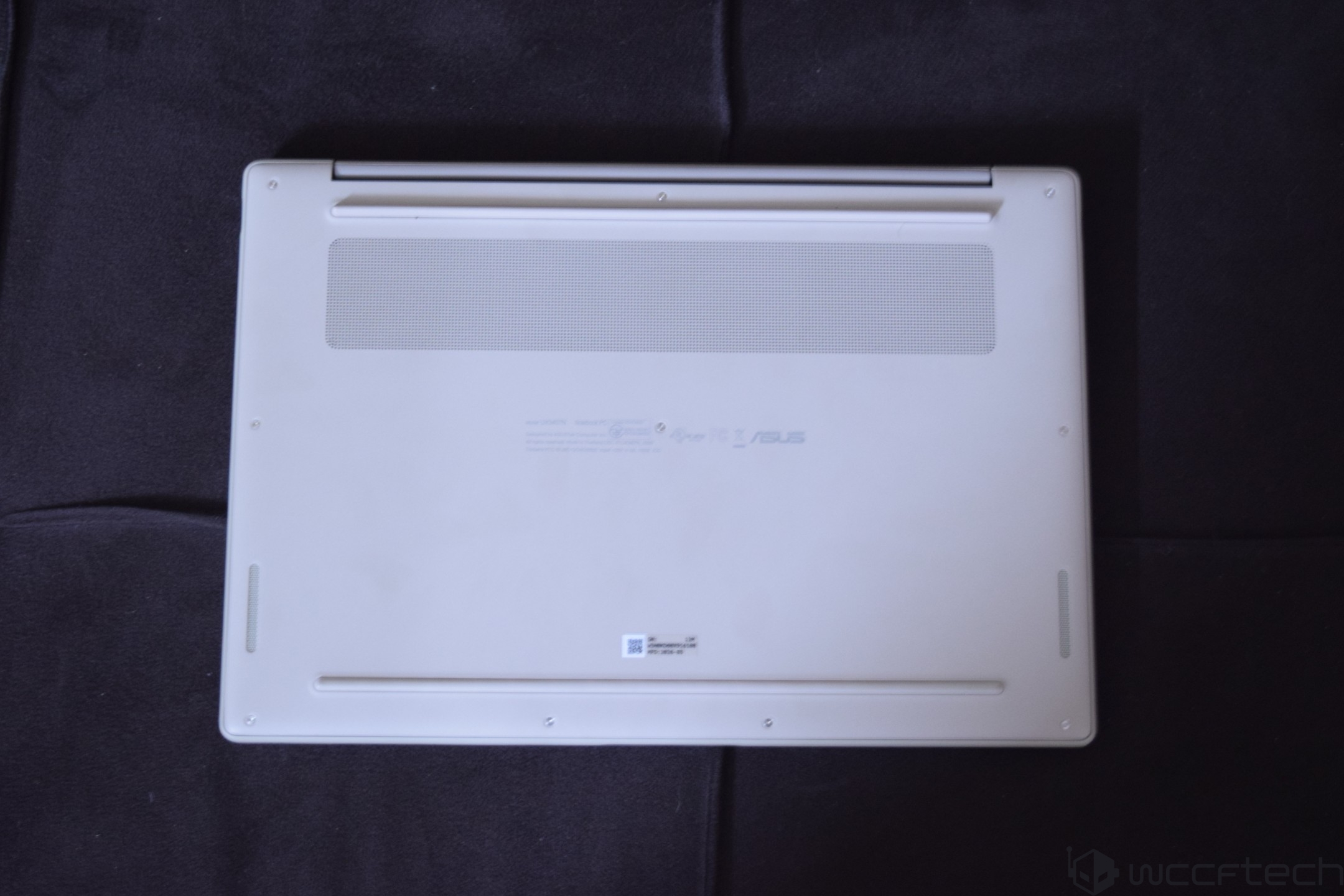 The underside of an ASUS ZenBook 13, featuring a visible ventilation grille and rubber feet.