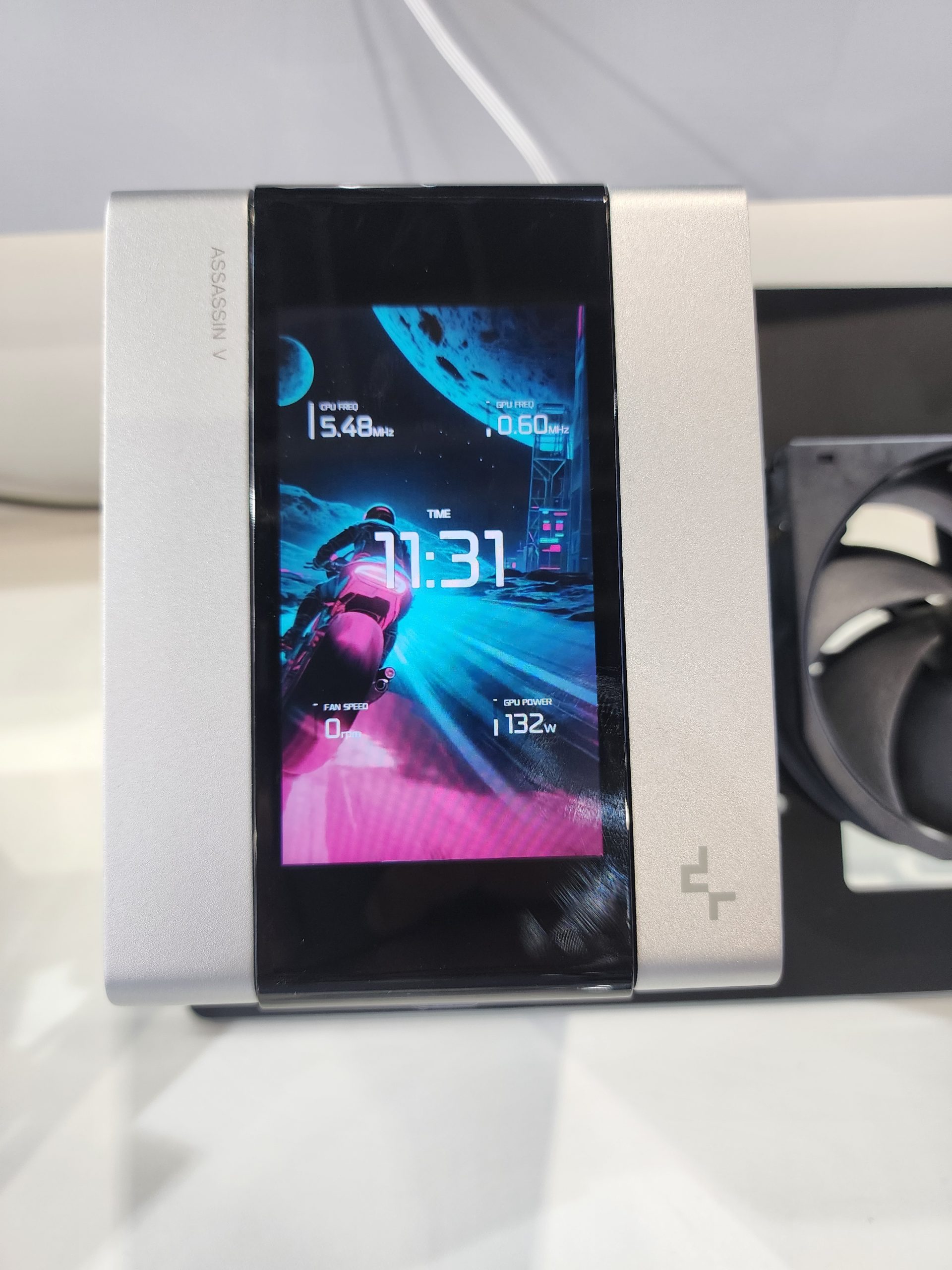 A DeepCool Assassin V cooler features a digital display showing 'GPU FREQ 1.548 MHz' and 'TIME 11:31' with a space-themed background.