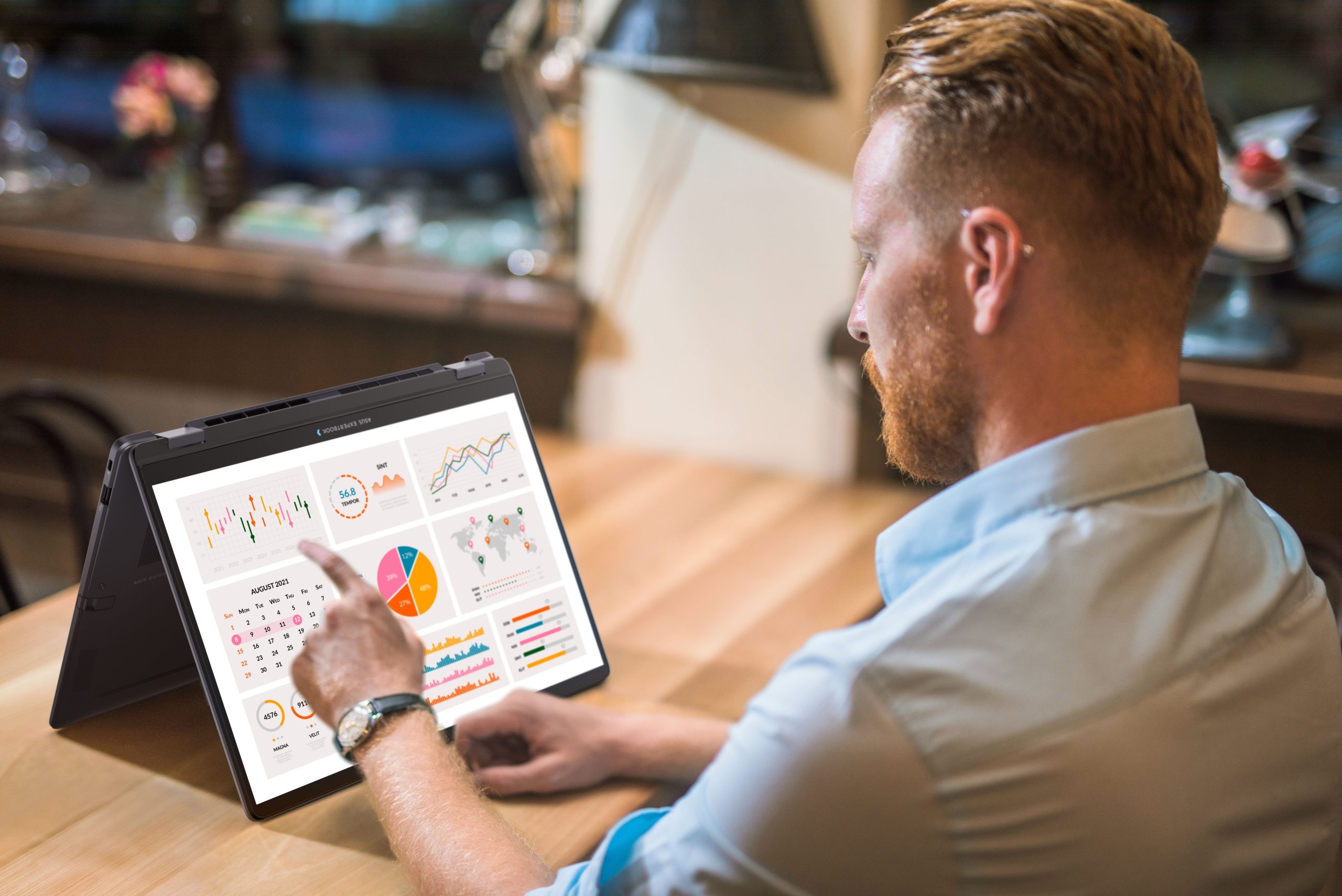 A person interacts with a Lenovo Ideapad Flex 5, displaying various charts and graphs on its screen.