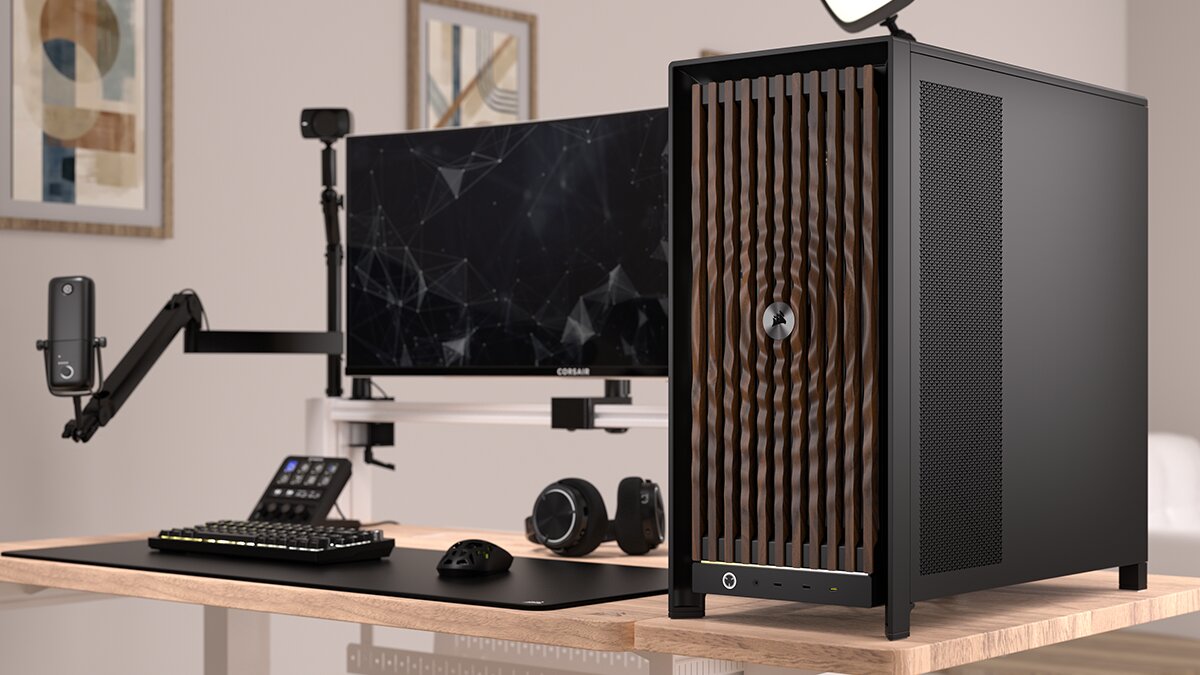 A Corsair monitor setup with a Corsair computer case featuring a distinctive wooden front panel, accompanied by a mechanical keyboard and mouse on a wooden desk.