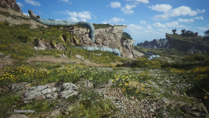 A scenic landscape from the game 'Crimson Desert', featuring rocky cliffs with large industrial pipes and windmills in the distance, with the 'C Commands Menu' visible on screen.
