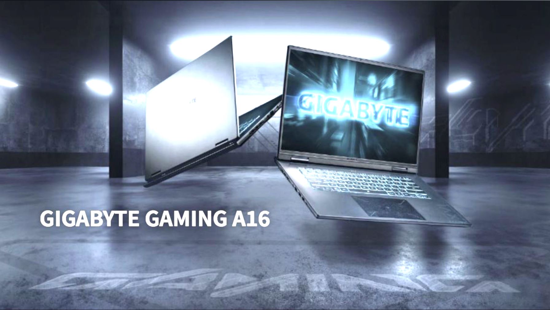 The image shows two Gigabyte Gaming A16 laptops in a dimly lit room, with one displaying the 'GIGABYTE' logo on its screen.