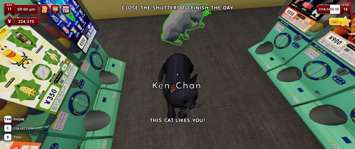 A digital display in a game shows a black cat named Ken-Chan with the text 'THIS CAT LIKES YOU!' next to vending machines labeled with yen prices, including '¥350.'