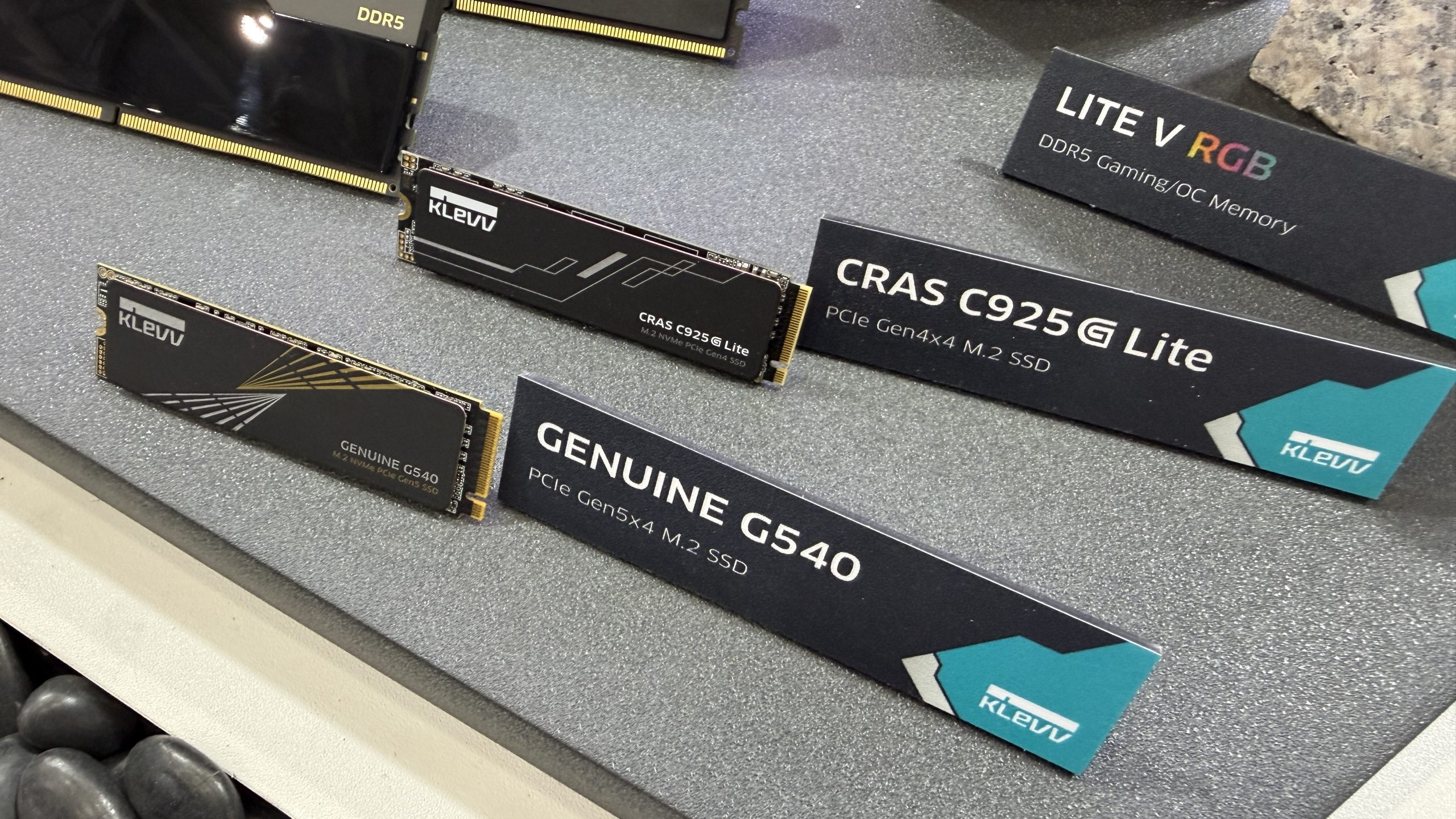KLEVV displays three storage products: the 'GENUINE G540' PCIe Gen5x4 M.2 SSD, the 'CRAS C925G Lite' PCIe Gen4x4 M.2 SSD, and the LITE V RGB DDR5 Gaming/OC Memory.