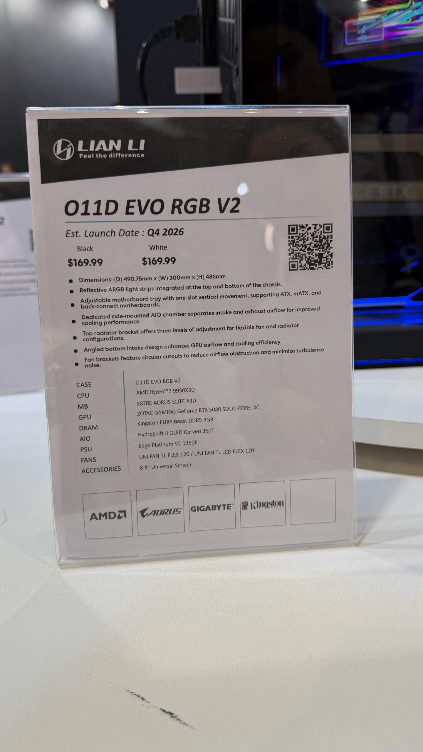 A display stand shows a product sheet for the Lian Li O11D EVO RGB V2 with an estimated launch date of Q4 2026 and a price of $169.99 for both black and white versions, listing components including AMD Ryzen 9 7950X3D CPU, ZOTAC GAMING GeForce RTX 5080 GPU, and Kingston FURY Beast DDR5 DRAM.