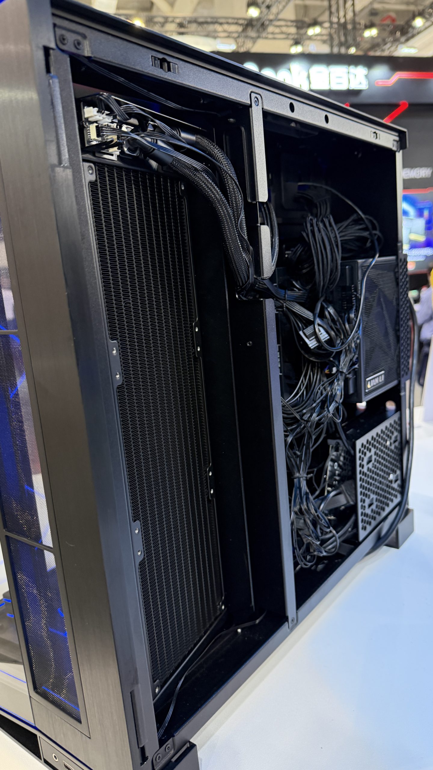 The image shows an unbranded desktop PC case with visible cables and a large cooling radiator, highlighting internal cable management.