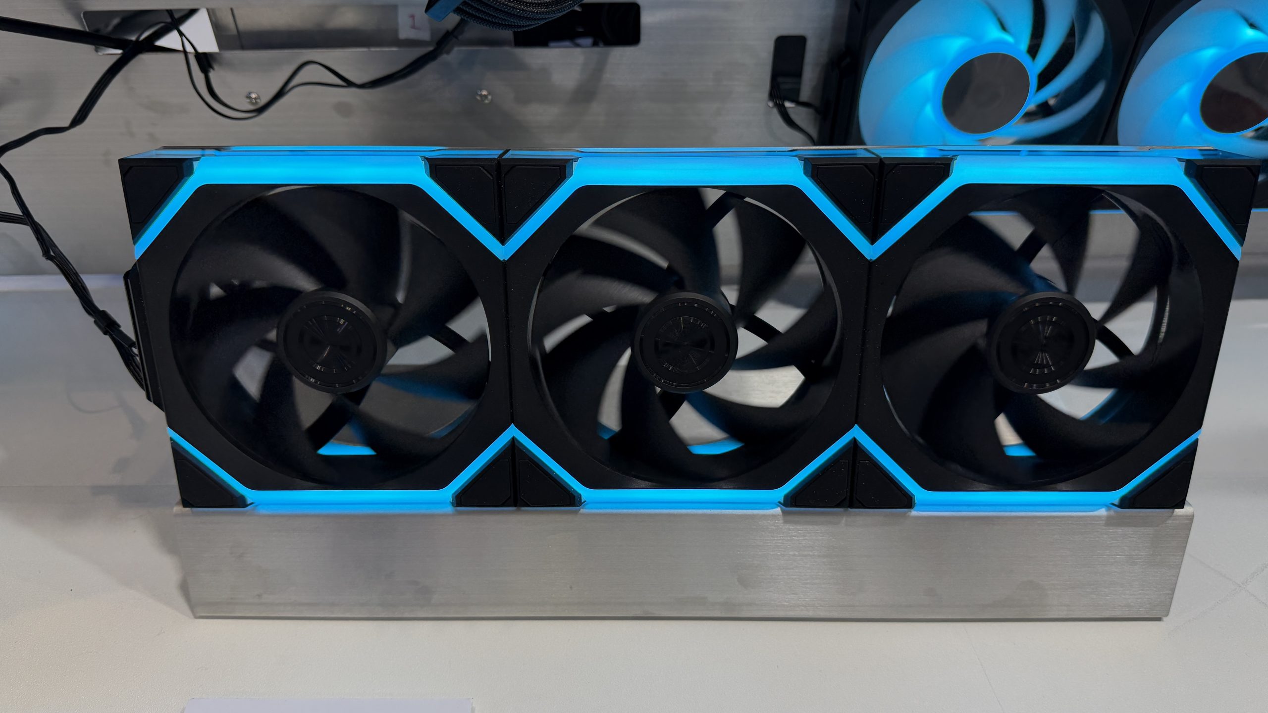 Three unbranded cooling fans with blue LED lighting are mounted on a metal stand.