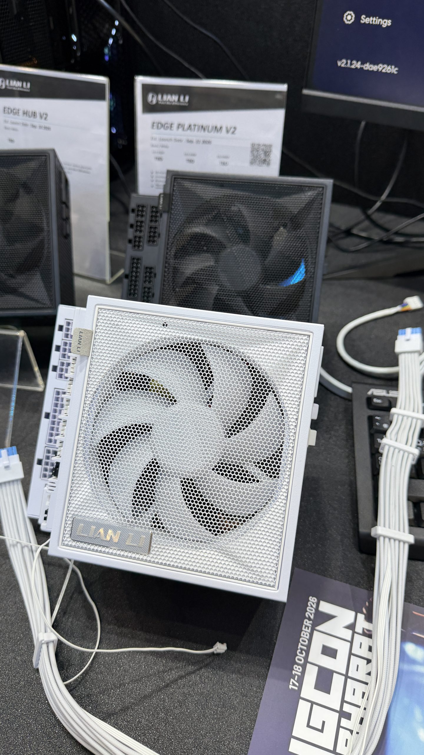 A Lian Li Edge Platinum V2 PSU is displayed on a table alongside labeled product information cards and white cables.