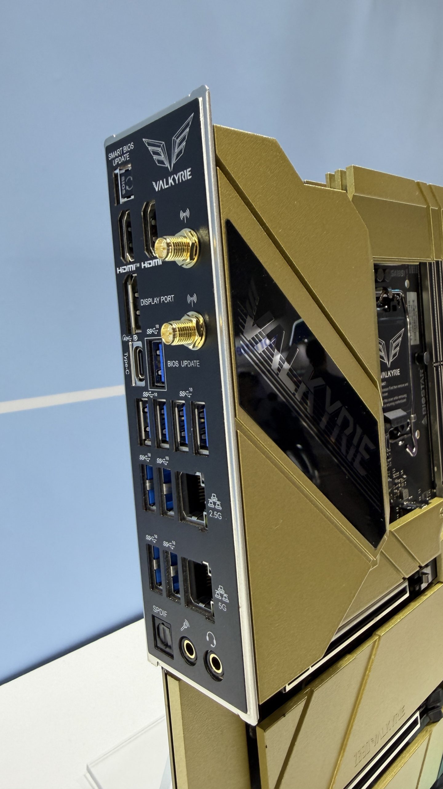 The rear I/O panel of a gold VALKYRIE motherboard features multiple USB ports, HDMI, Display Port, Ethernet ports labeled '2.5G' and '5G,' and audio jacks with 'SMART BIOS UPDATE' text.