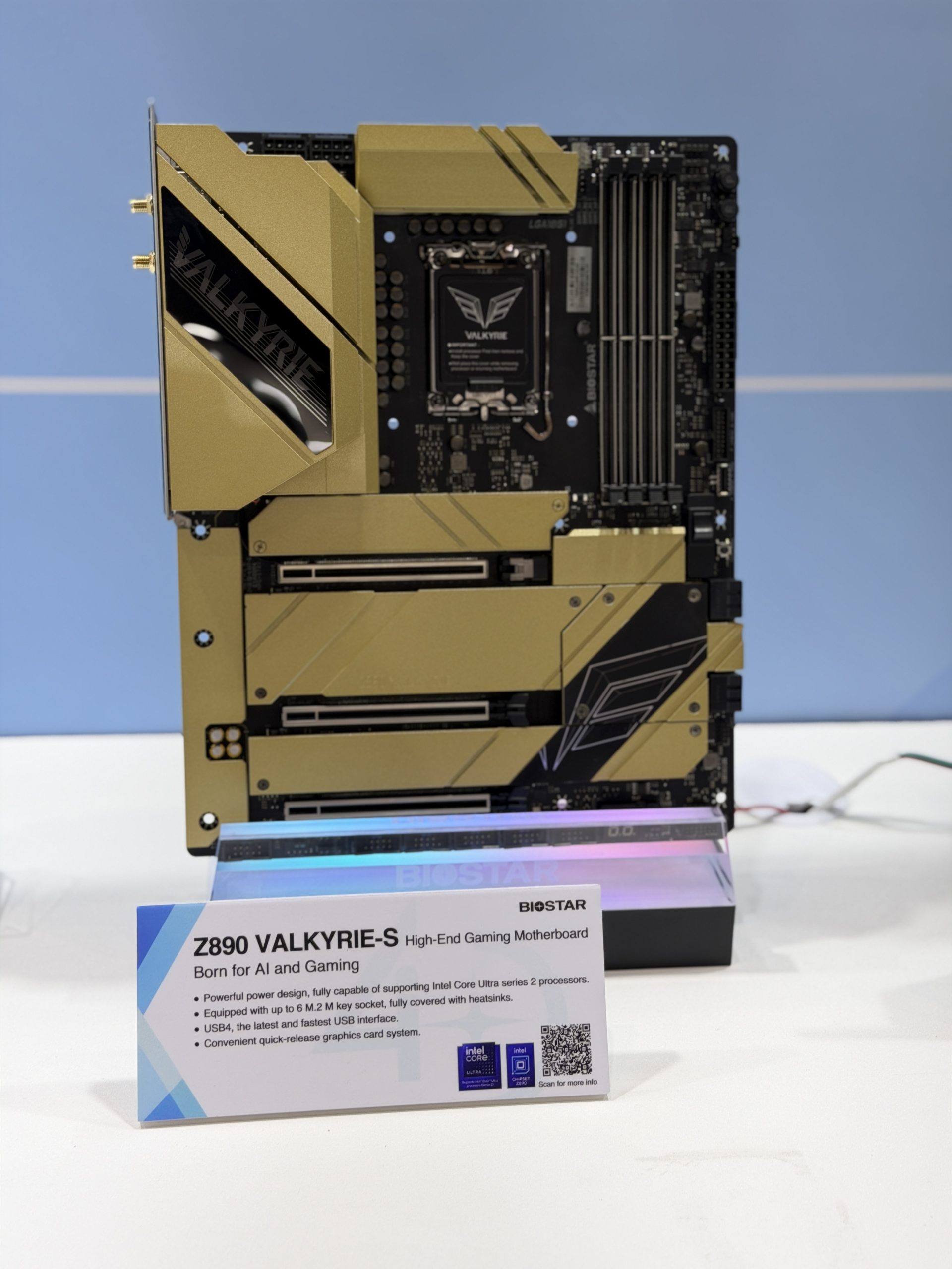The image shows a Biostar Z890 VALKYRIE-S high-end gaming motherboard with a gold and black design, displayed alongside a sign highlighting features like support for Intel Core Ultra series 2 processors and USB4 interfaces.