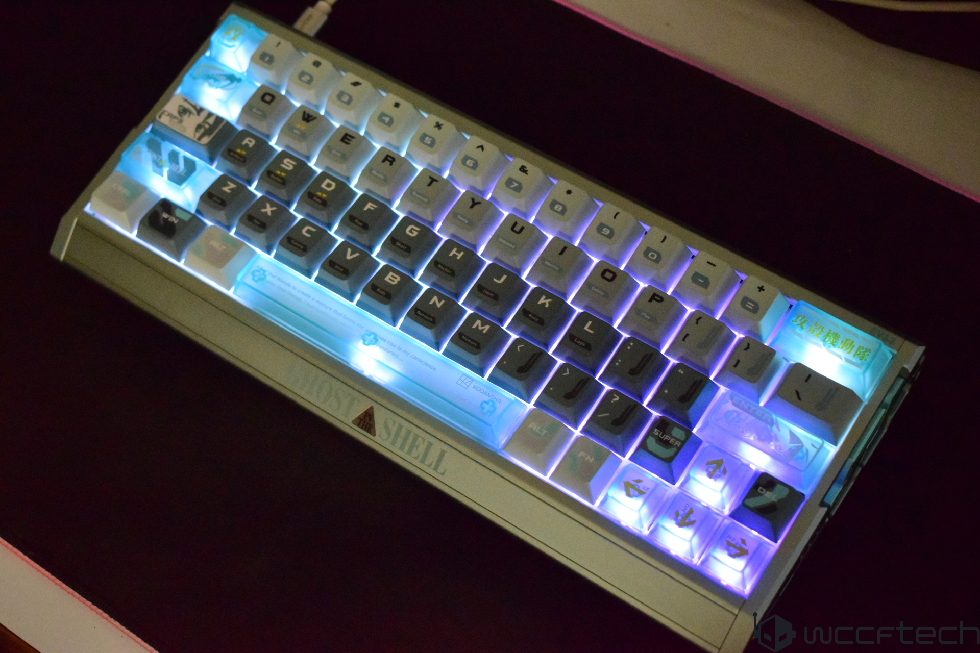 A Ghost Shell mechanical keyboard with customizable RGB backlighting and unique keycap designs is illuminated in various colors.