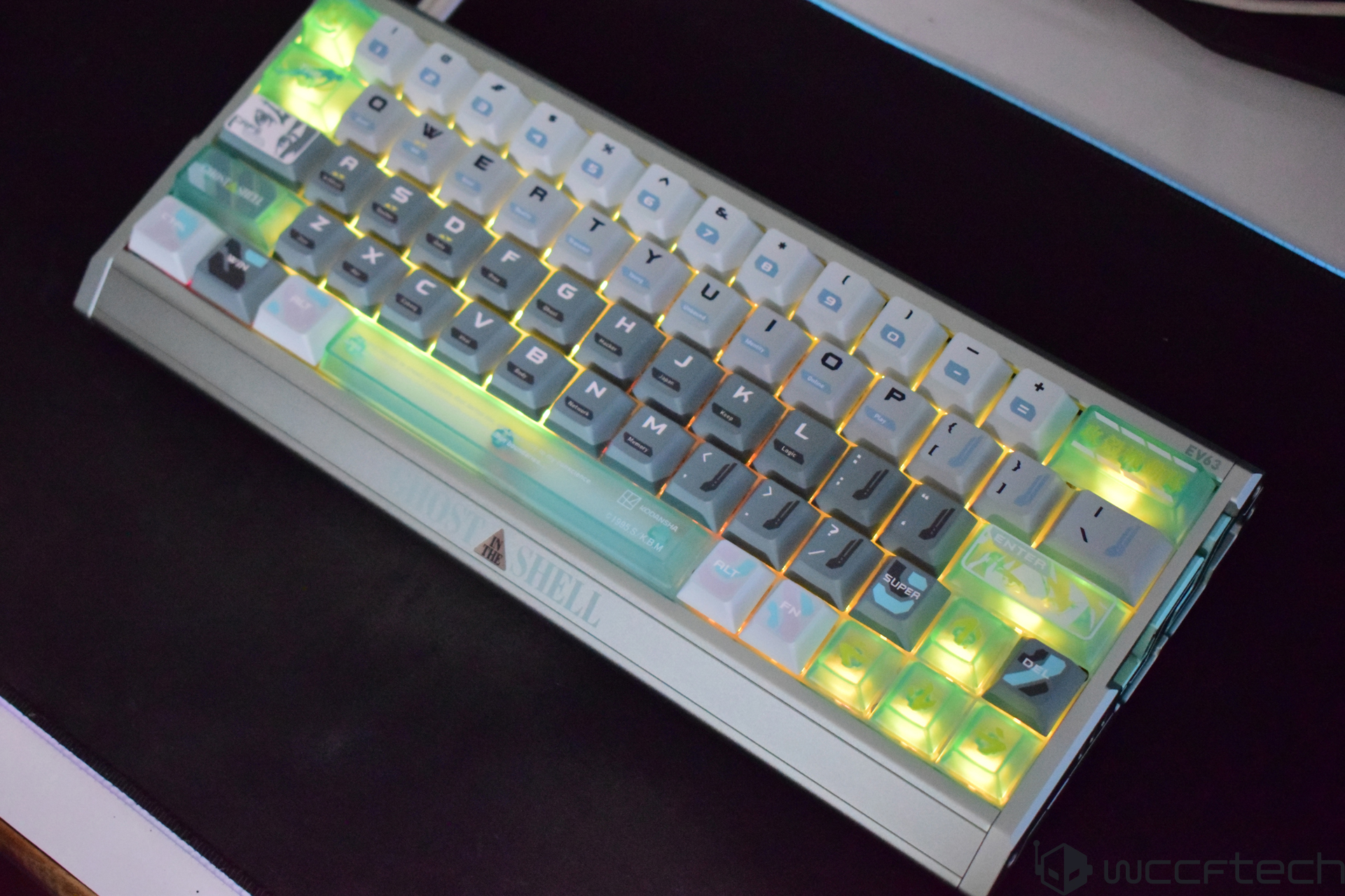 An X-VX EV63 mechanical keyboard featuring a 'Ghost in the Shell' design with backlit keys.