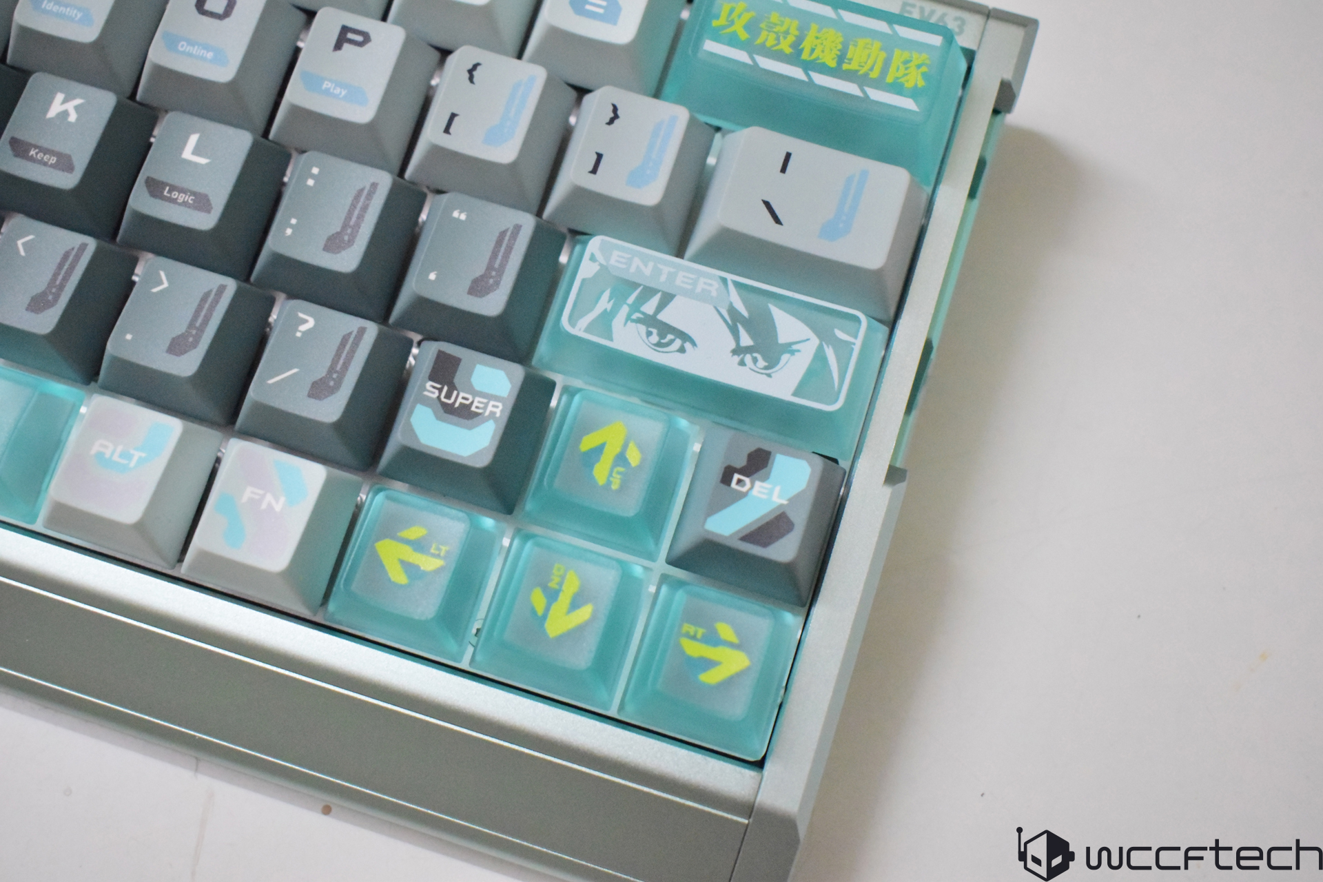 A mechanical keyboard features themed keycaps with an anime-style eye design on the 'ENTER' key and various symbols and text on other keys.