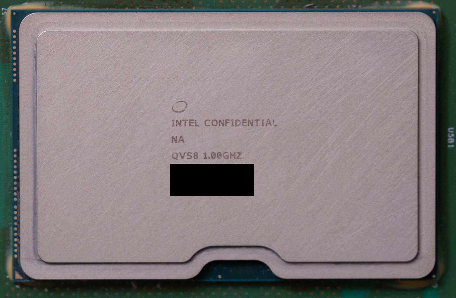 A close-up of an Intel processor labeled 'INTEL CONFIDENTIAL,' 'QVS8 1.00GHZ,' with parts of the text blacked out.