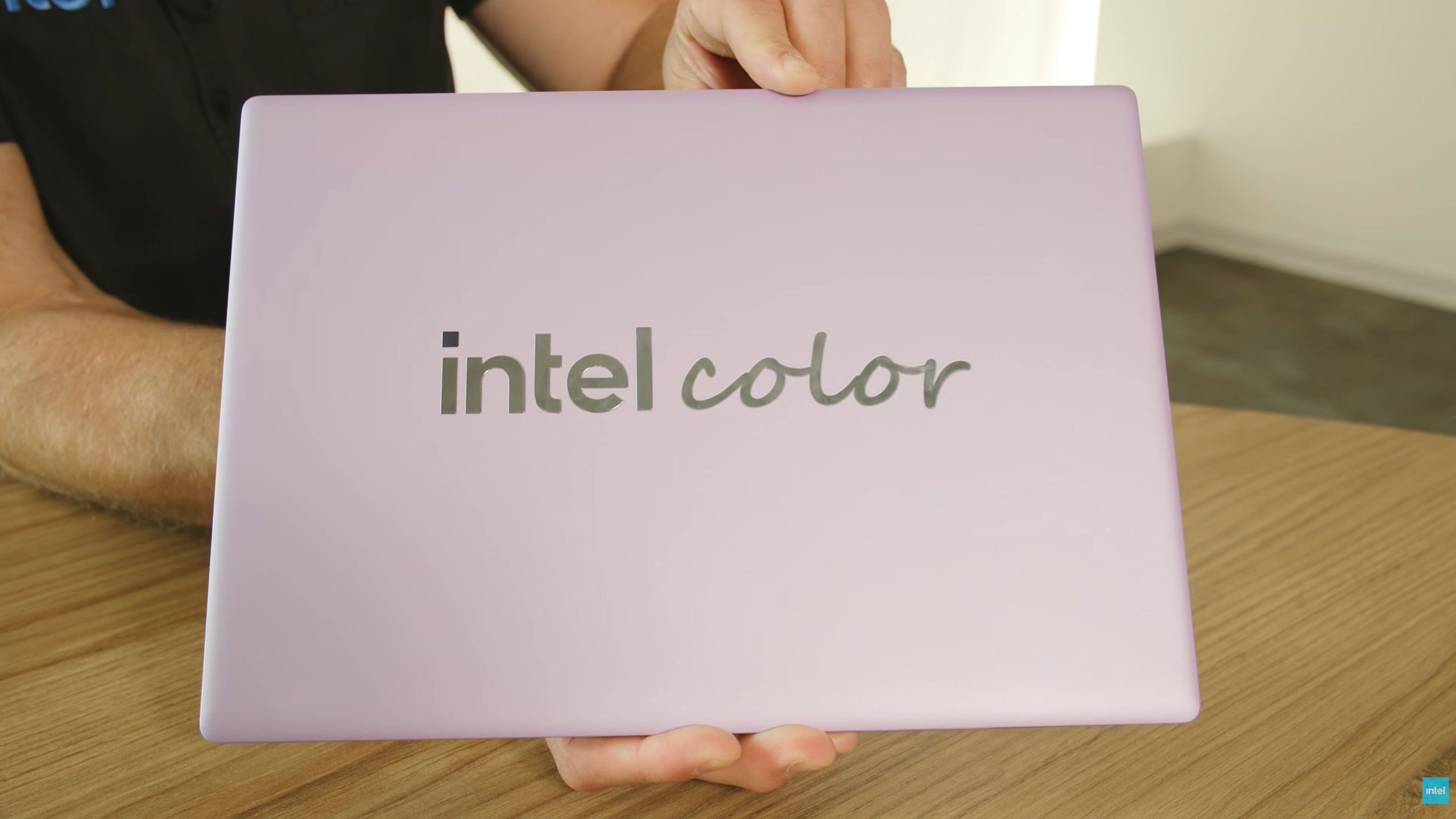 A person holds a lavender-colored laptop with the text 'intel color' on the lid.