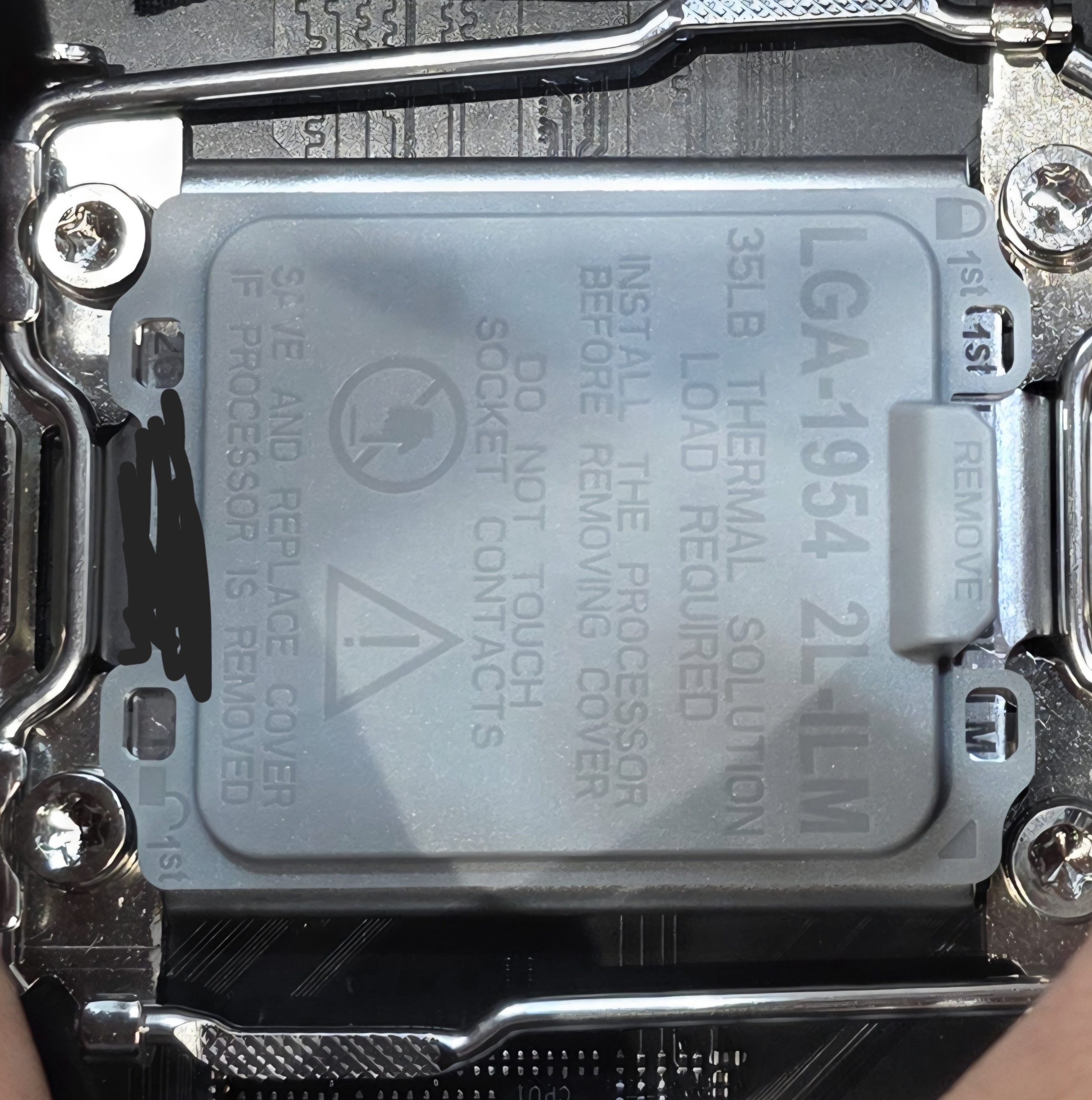 A close-up of an LGA-1954 CPU socket cover showing instructions and a '35LB THERMAL SOLUTION LOAD REQUIRED' warning.