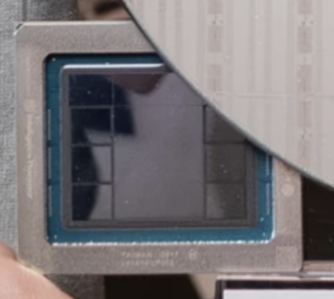A close-up image of an AMD processor chip surrounded by a wafer.