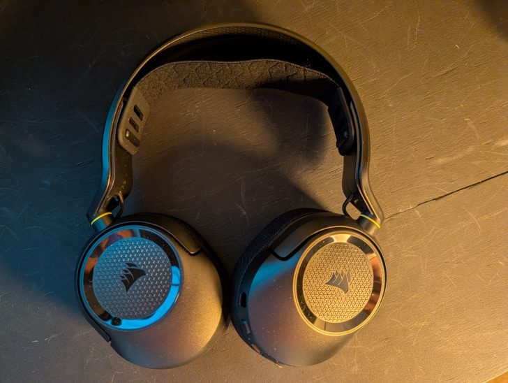 A pair of Corsair gaming headphones on a dark surface, arranged in a smiley face shape.