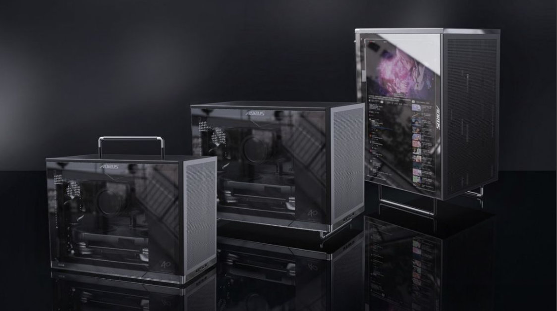 Three AORUS branded computer cases of different sizes are displayed side by side, with the largest case featuring a digital screen showing a YouTube interface.