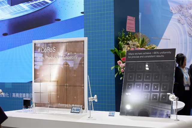 A display at a tech expo shows a 'Max. Production Capacity' Manz etching technology with two panels labeled '#CoPoS' and 'Manz etchers achieve >95% uniformity for precise and consistent results.'