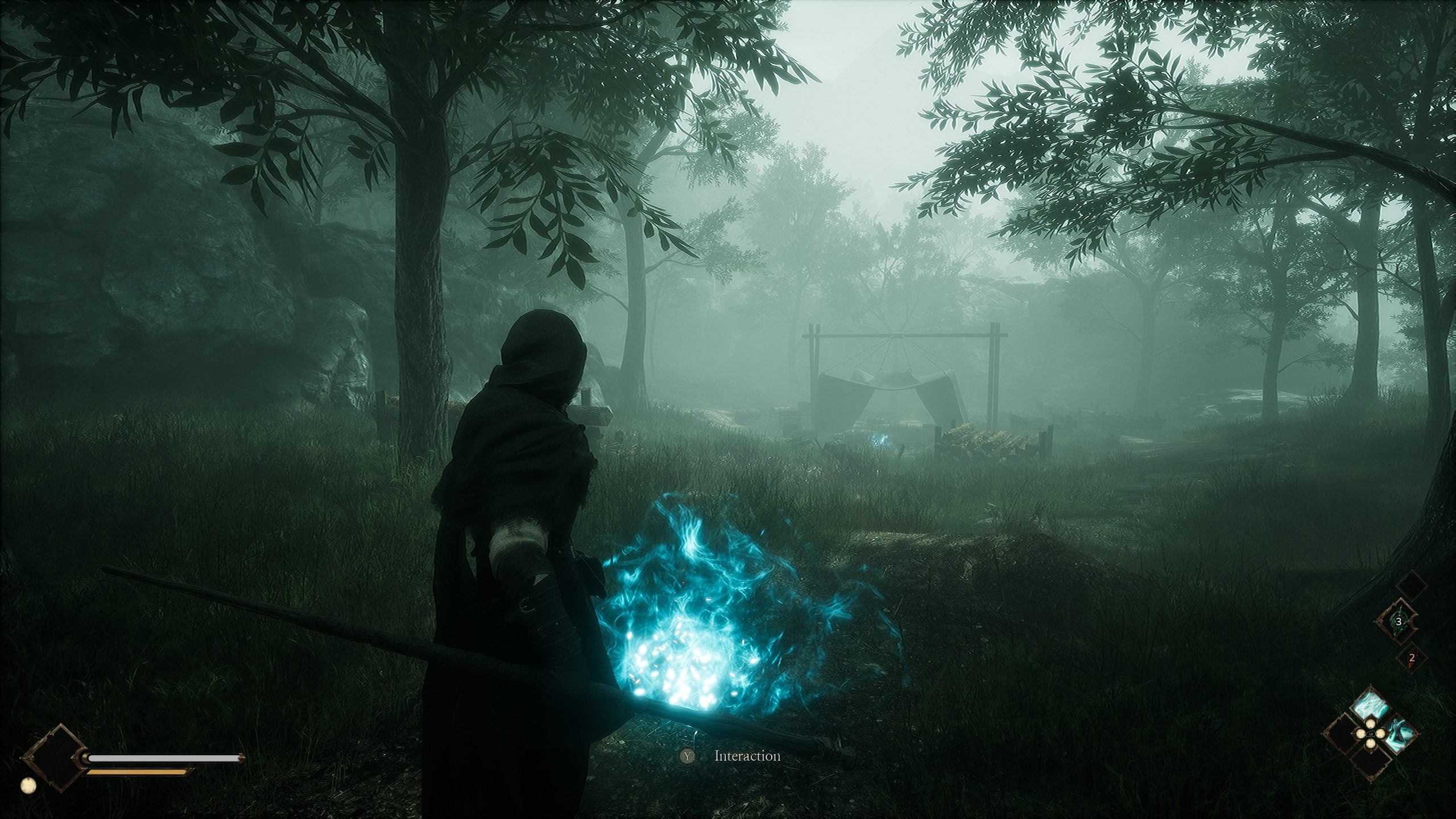 A hooded character holds a staff emitting blue flames in a forest setting, with a tent in the distance, and the on-screen prompt reads 'Y: Interaction'.